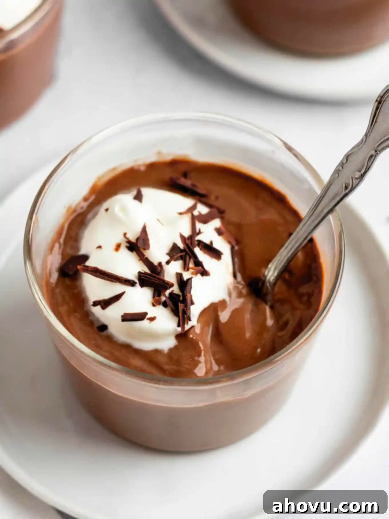Decadent Chocolate Delight 2 Homemade chocolate pudding garnished with whipped cream and chocolate shavings in a glass serving dish.