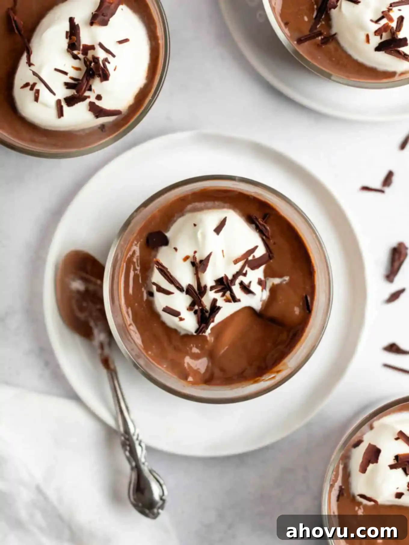 Decadent Chocolate Delight 11 An overhead view of a pot of chocolate pudding garnished with whipped cream and chocolate shavings.