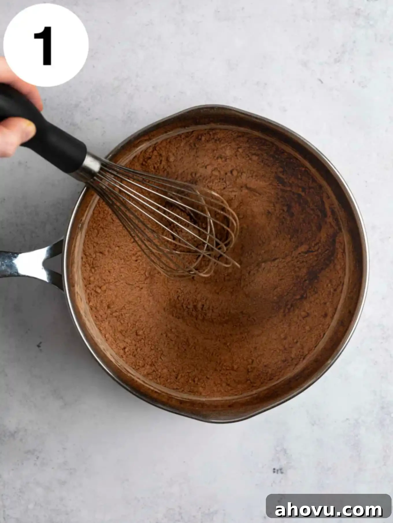 Decadent Chocolate Delight 4 An overhead view of a cocoa powder mixture in a metal saucepan.