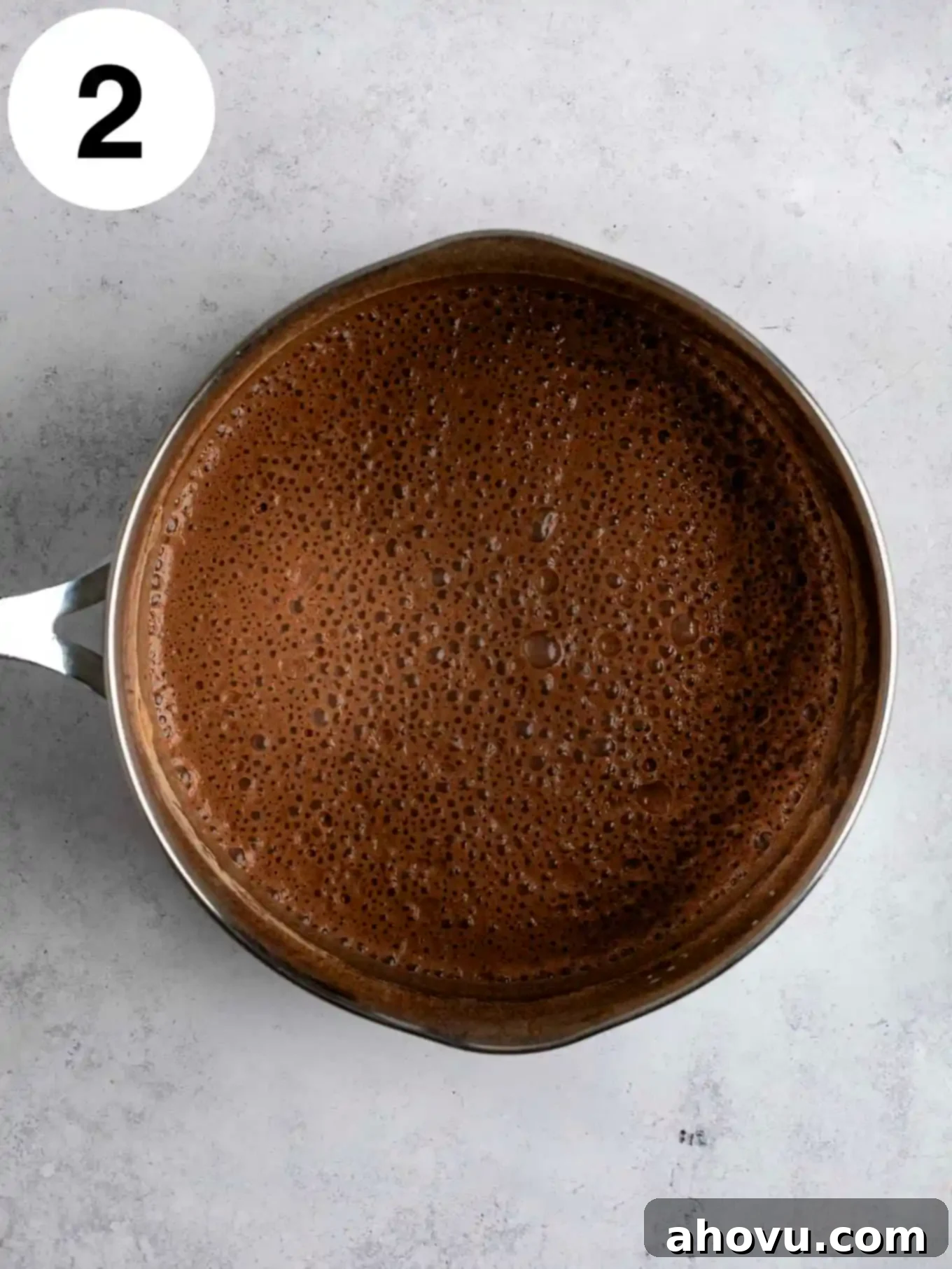 Decadent Chocolate Delight 5 An overhead view of a milk and cocoa powder mixture in a metal saucepan.