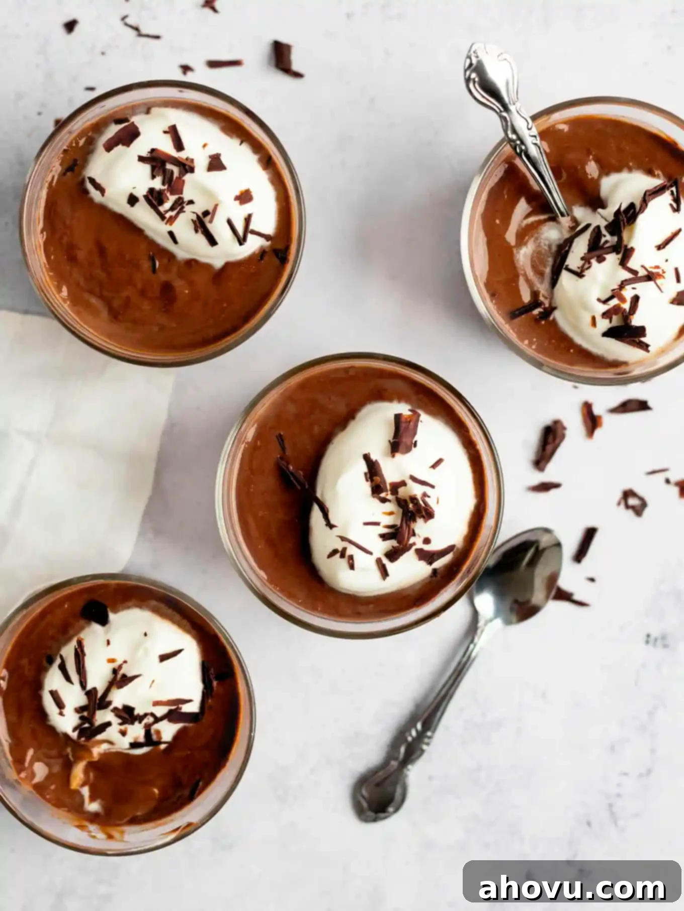 Decadent Chocolate Delight 10 An overhead view of four pots of chocolate pudding garnished with whipped cream and chocolate shavings.