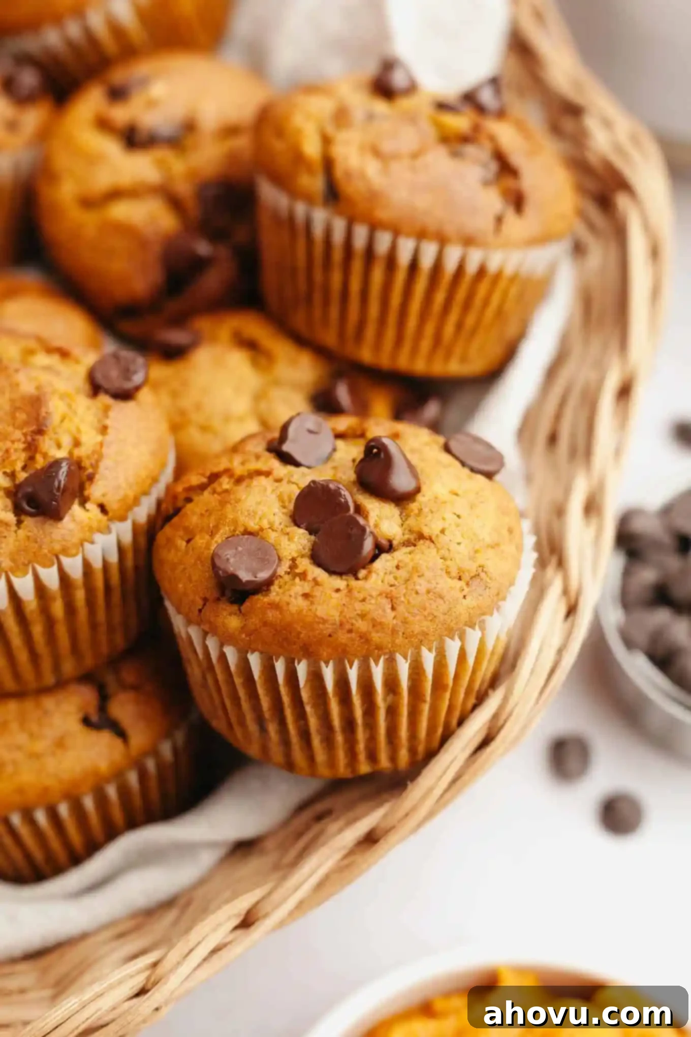 Cozy Pumpkin Chocolate Morsel Muffins 2 Chocolate chip and pumpkin muffins piled into a wicker serving basket.