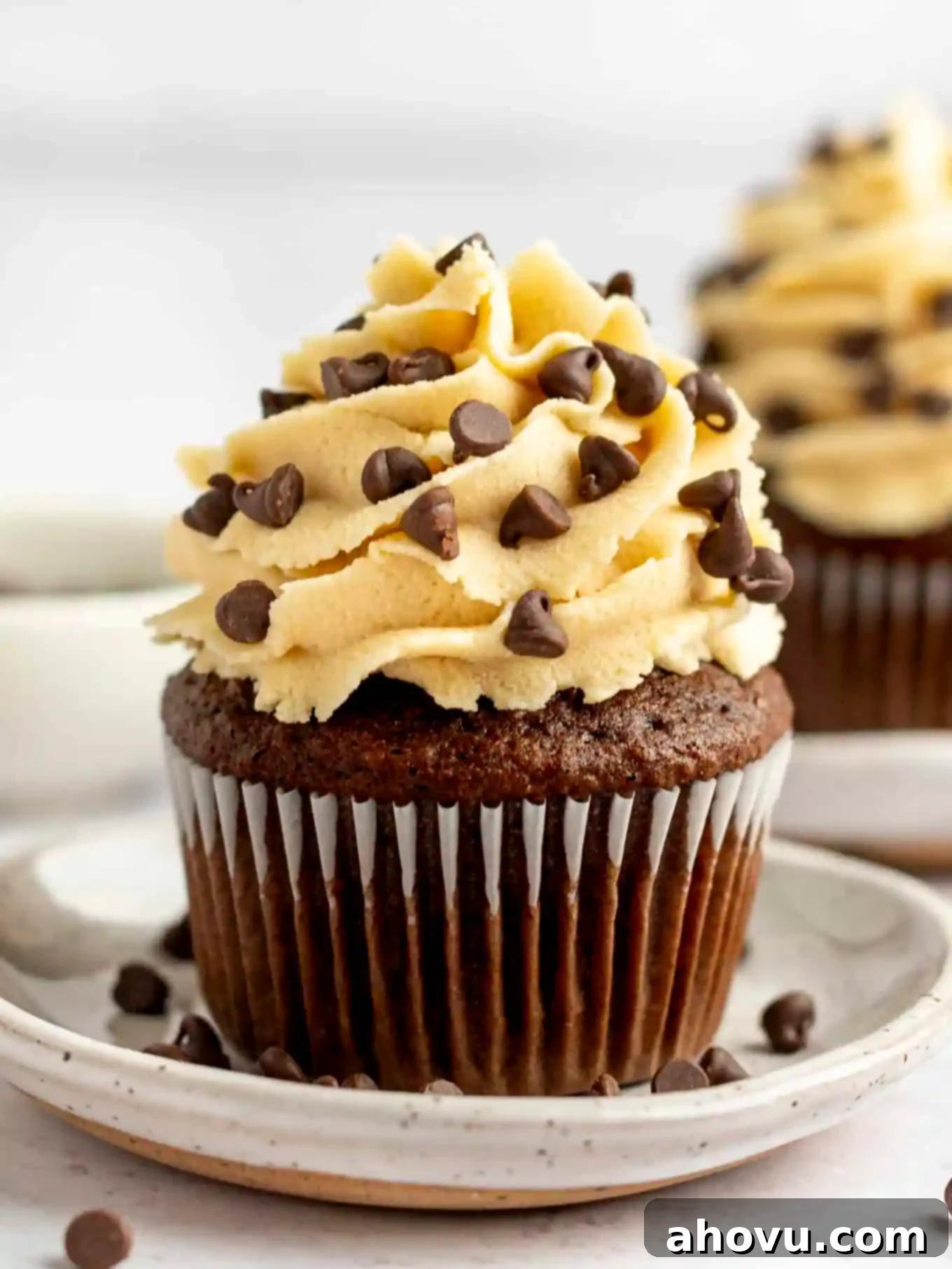 A chocolate cupcake beautifully piped with rich, creamy cookie dough frosting and mini chocolate chips.