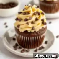 A chocolate cupcake topped with irresistible cookie dough frosting, adorned with mini chocolate chips, inviting you to take a bite.