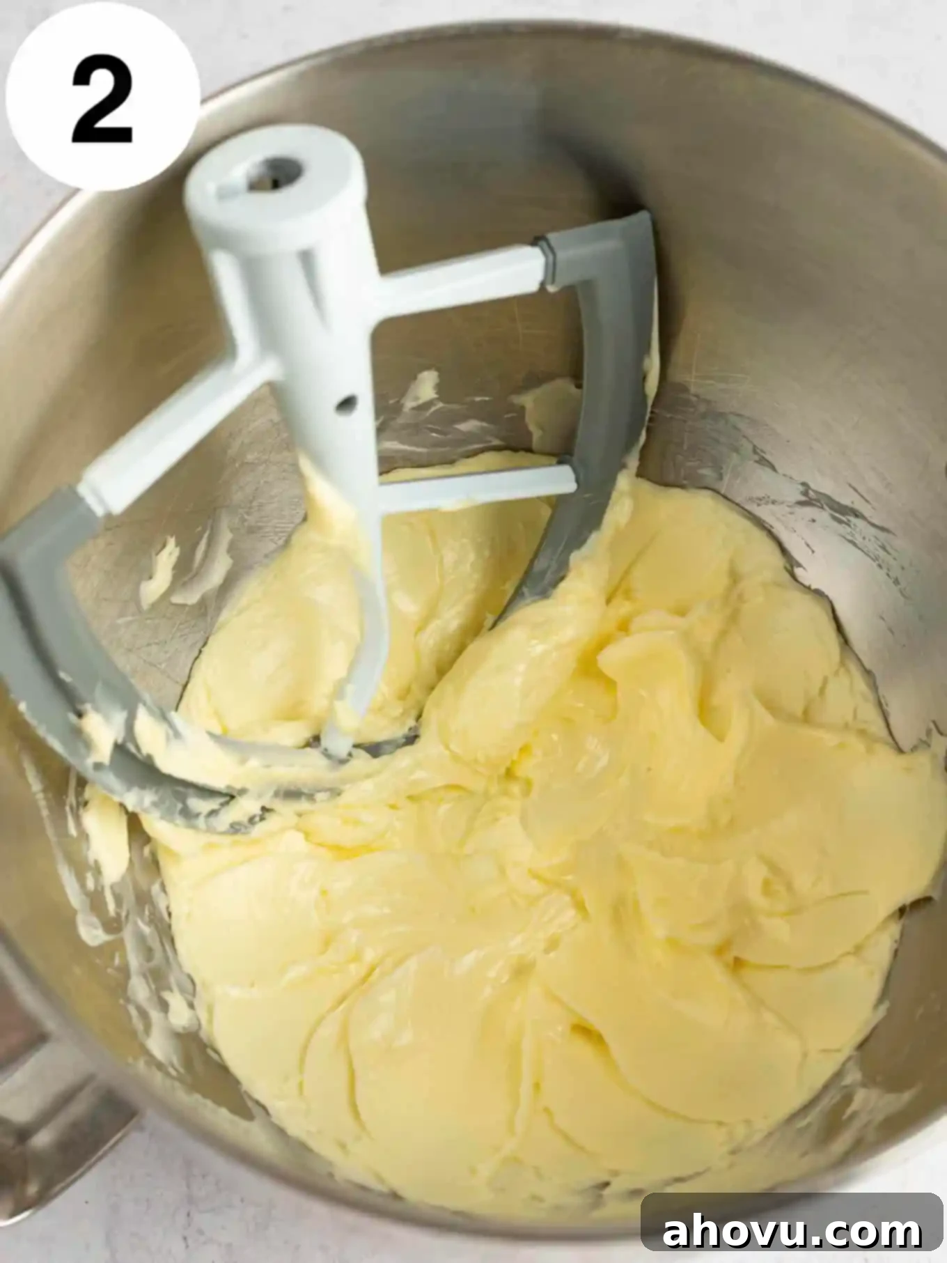 An overhead view of beautifully beaten, softened butter in the bowl of a stand mixer, demonstrating the ideal creamy texture before adding sugars.