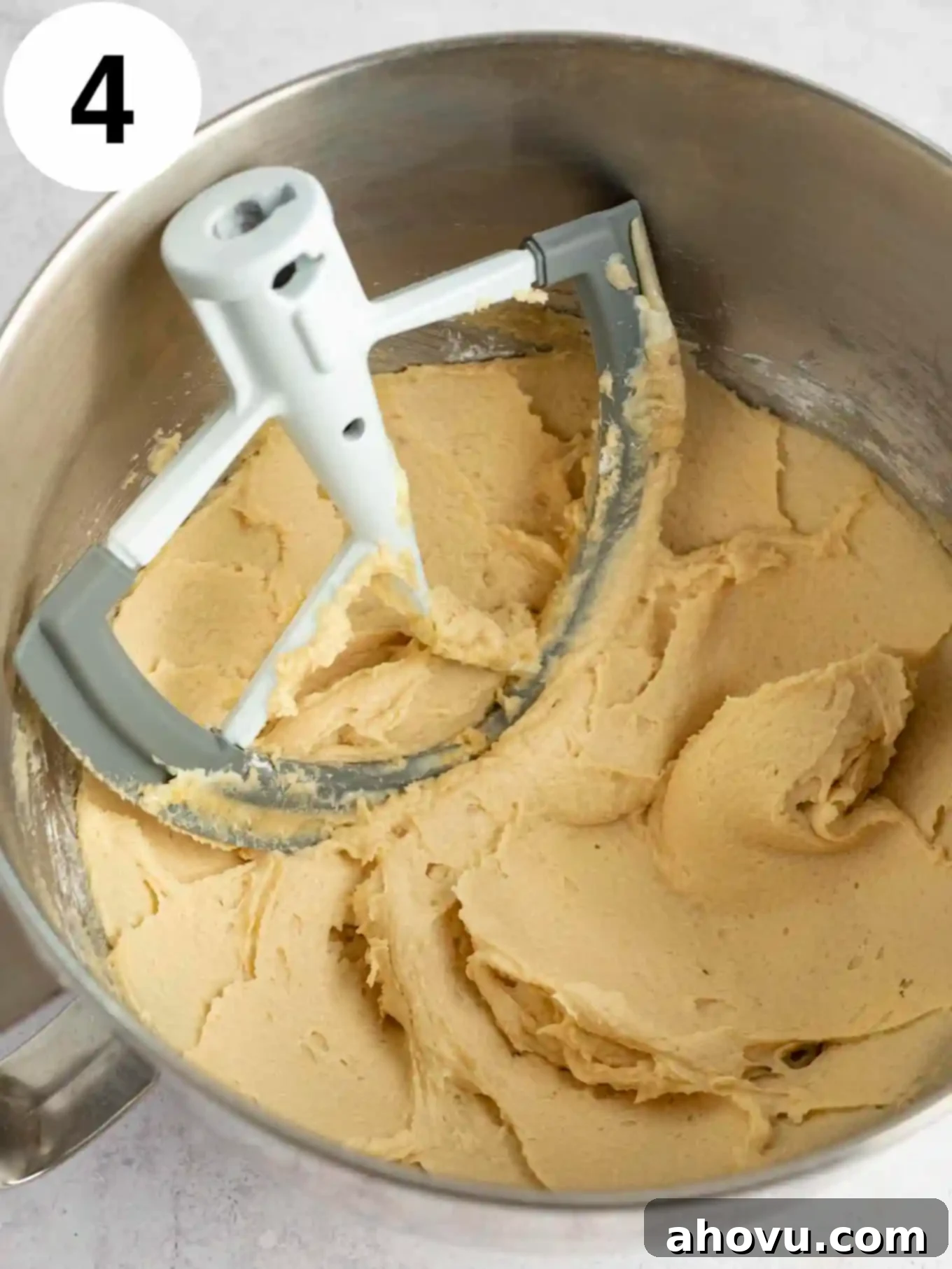 An overhead view of the stand mixer bowl with the brown sugar and powdered sugar mixture, perfectly blended into a creamy and smooth frosting base.