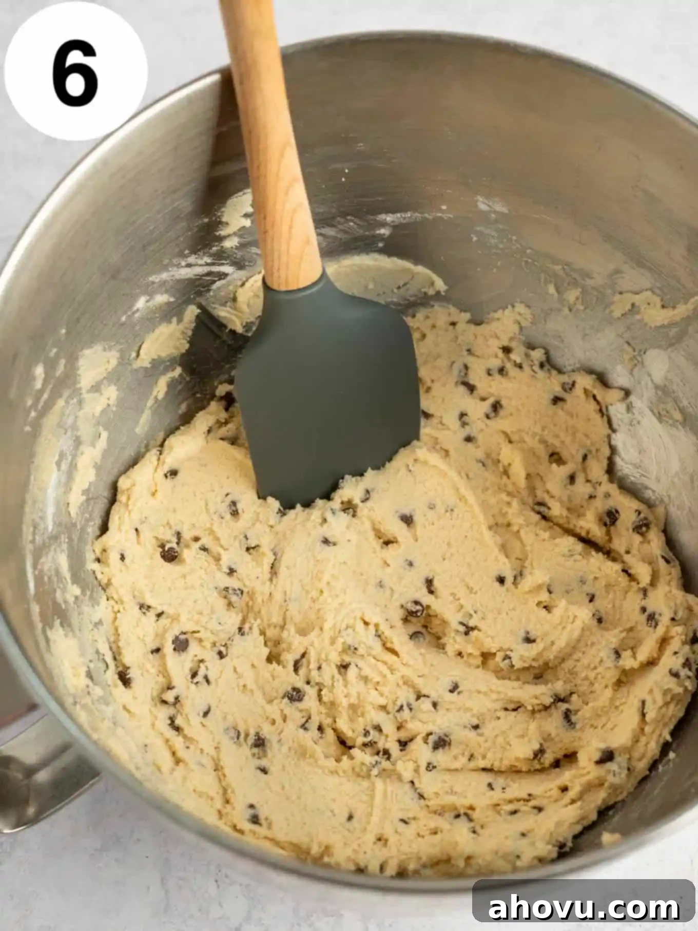 An overhead view of the final chocolate chip cookie dough frosting in the stand mixer, with mini chocolate chips perfectly folded in, ready to be used.