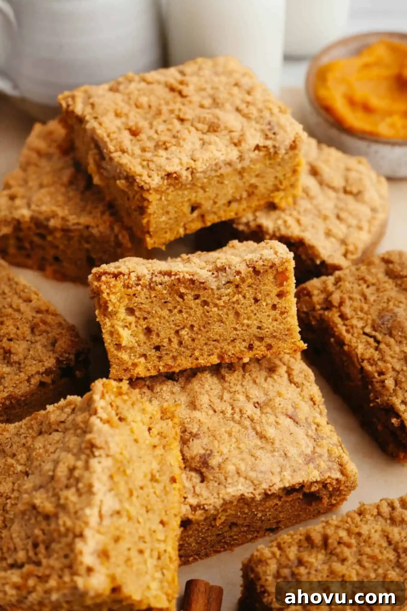 Slices of pumpkin streusel coffee cake piled on top of each other. 