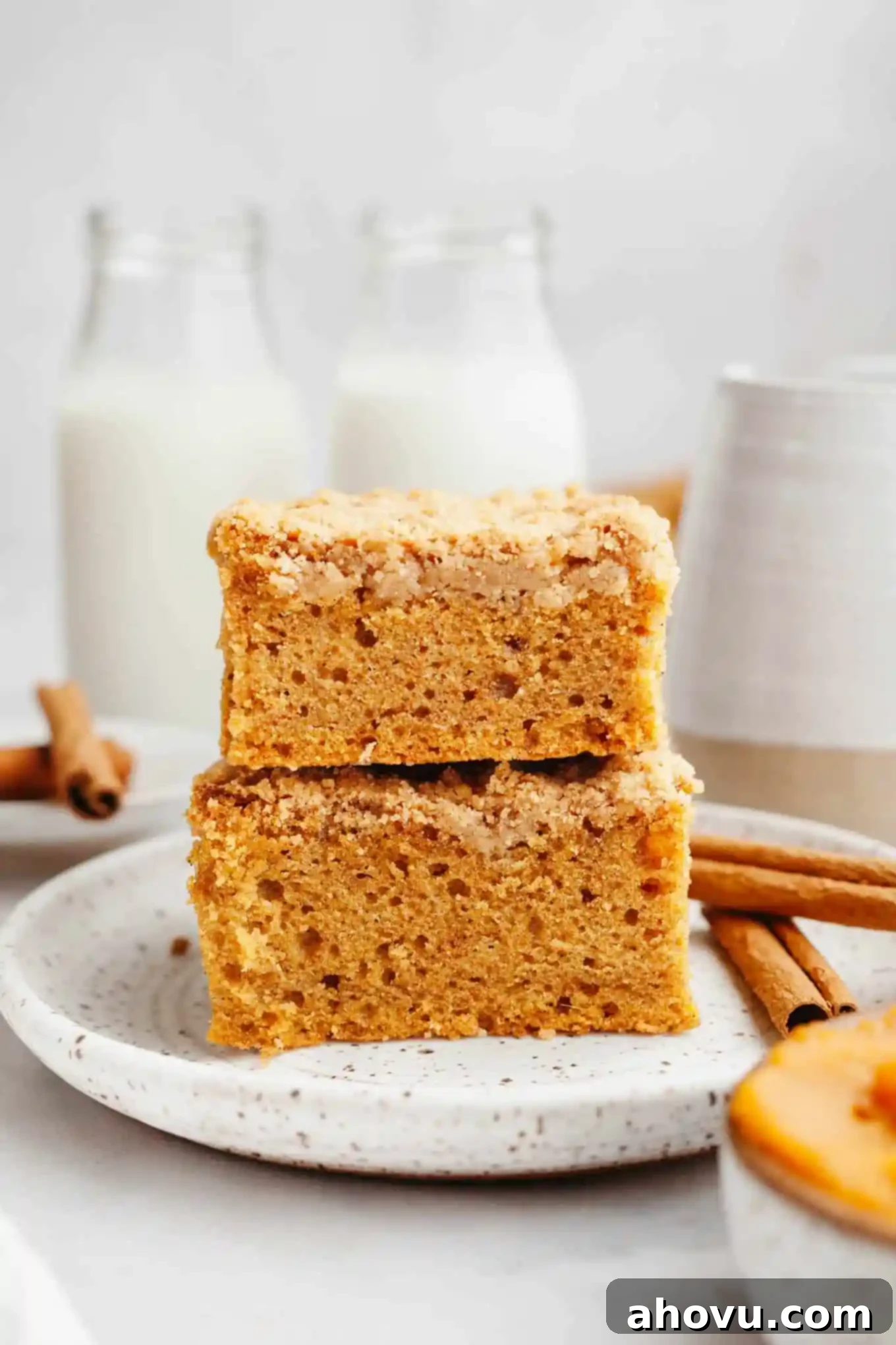 A stack of two slices of pumpkin coffee cake on a dessert plate, seen from the side. 