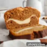Pumpkin Swirl Cream Cheese Bread 12 A freshly baked loaf of pumpkin cream cheese bread that has been expertly sliced, showcasing the rich, spiced pumpkin layers embracing a creamy, decadent cream cheese swirl.