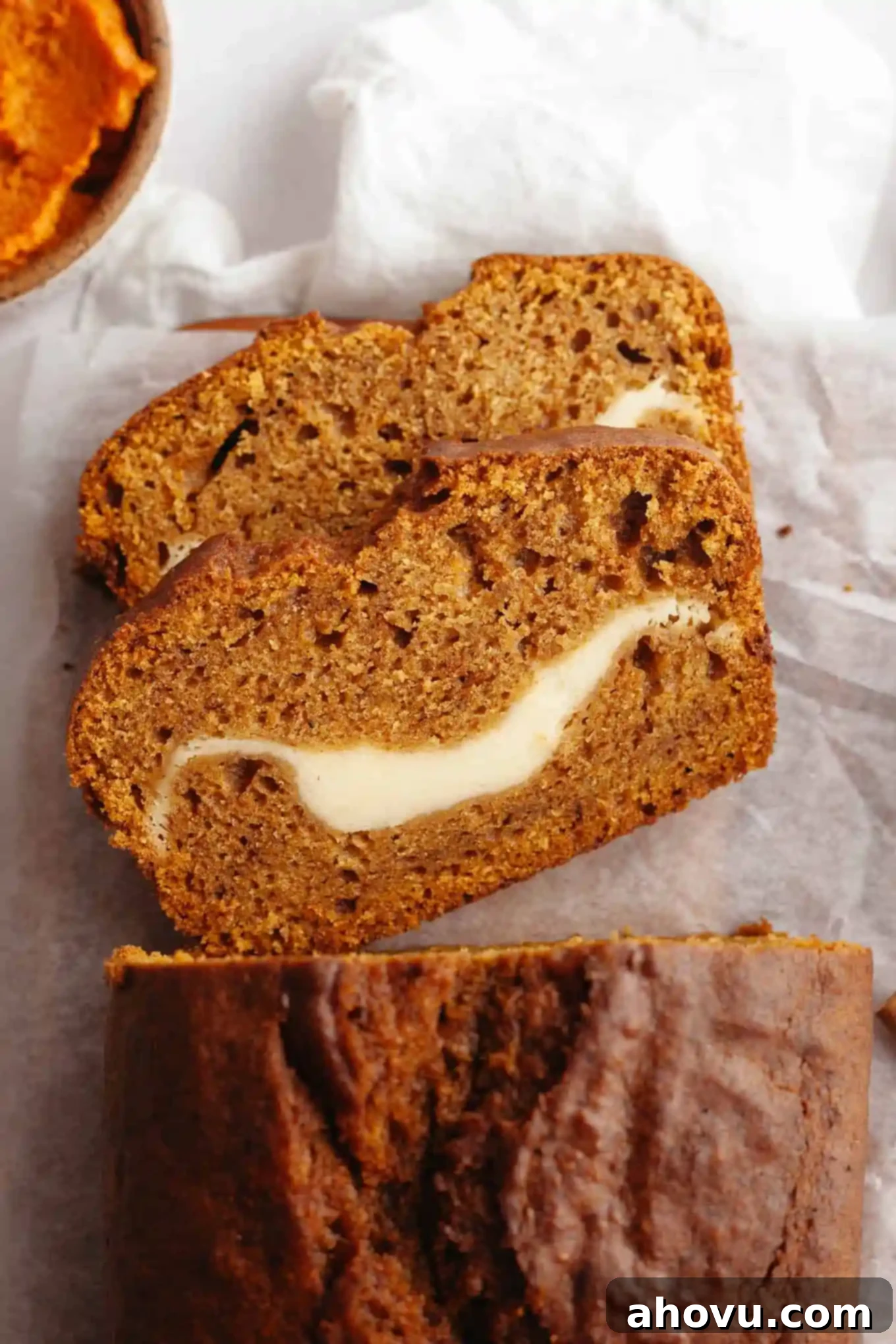 Pumpkin Swirl Cream Cheese Bread 10 An inviting overhead view of two thick slices of pumpkin cream cheese bread, perfectly displaying the rich pumpkin bread and the creamy white swirl of cream cheese filling.