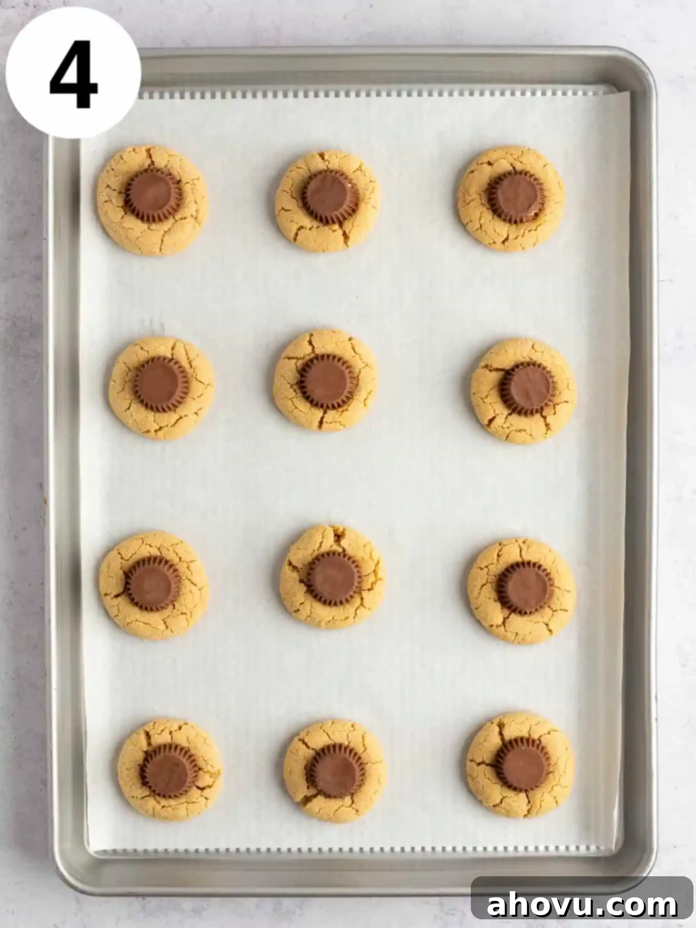 Creepy Crawly Cookie Bites 7 An overhead view of baked peanut butter cup blossom cookies on a parchment paper-lined baking sheet.