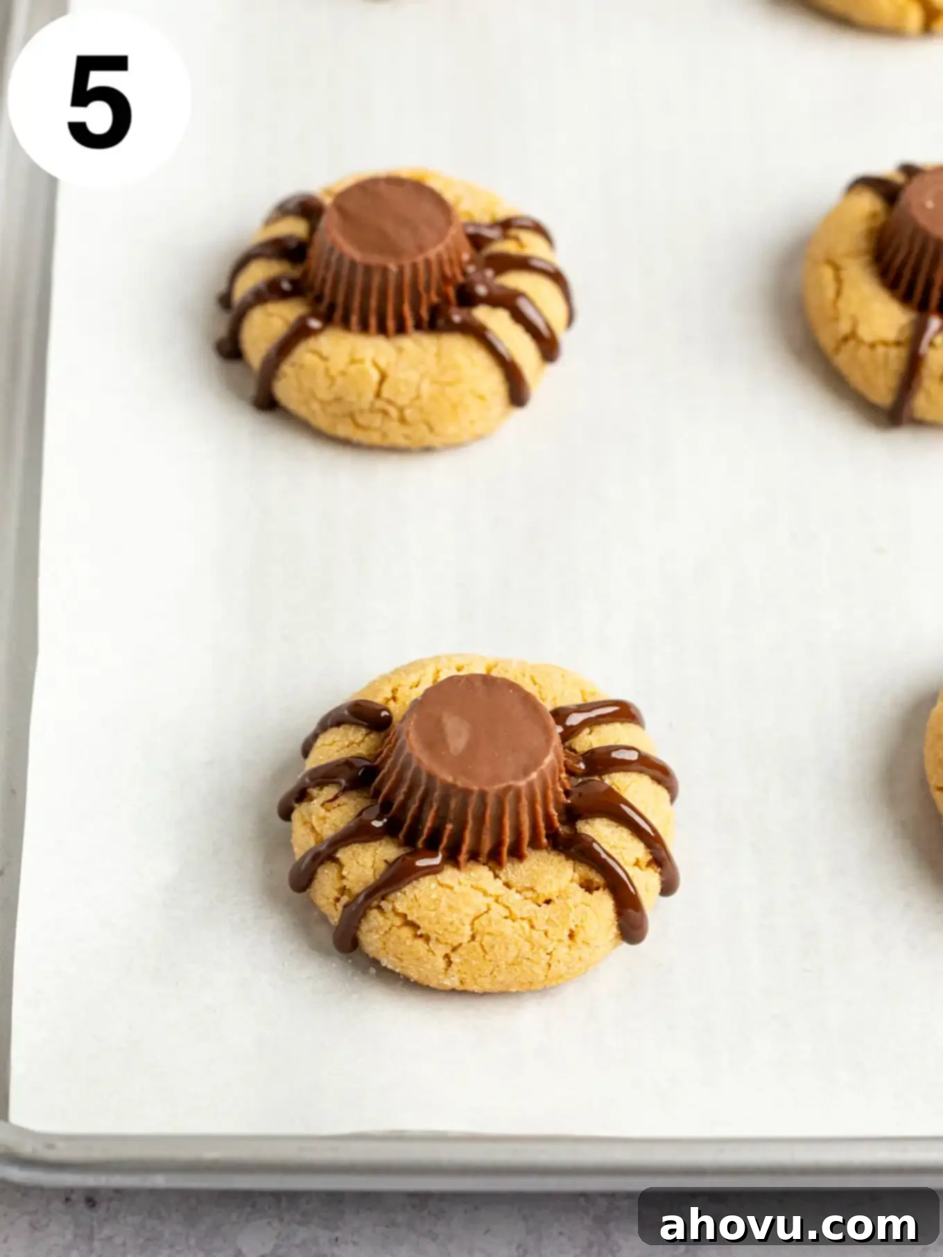 Creepy Crawly Cookie Bites 8 A process shot showing peanut butter cup cookies with spider legs piped onto them with melted chocolate.