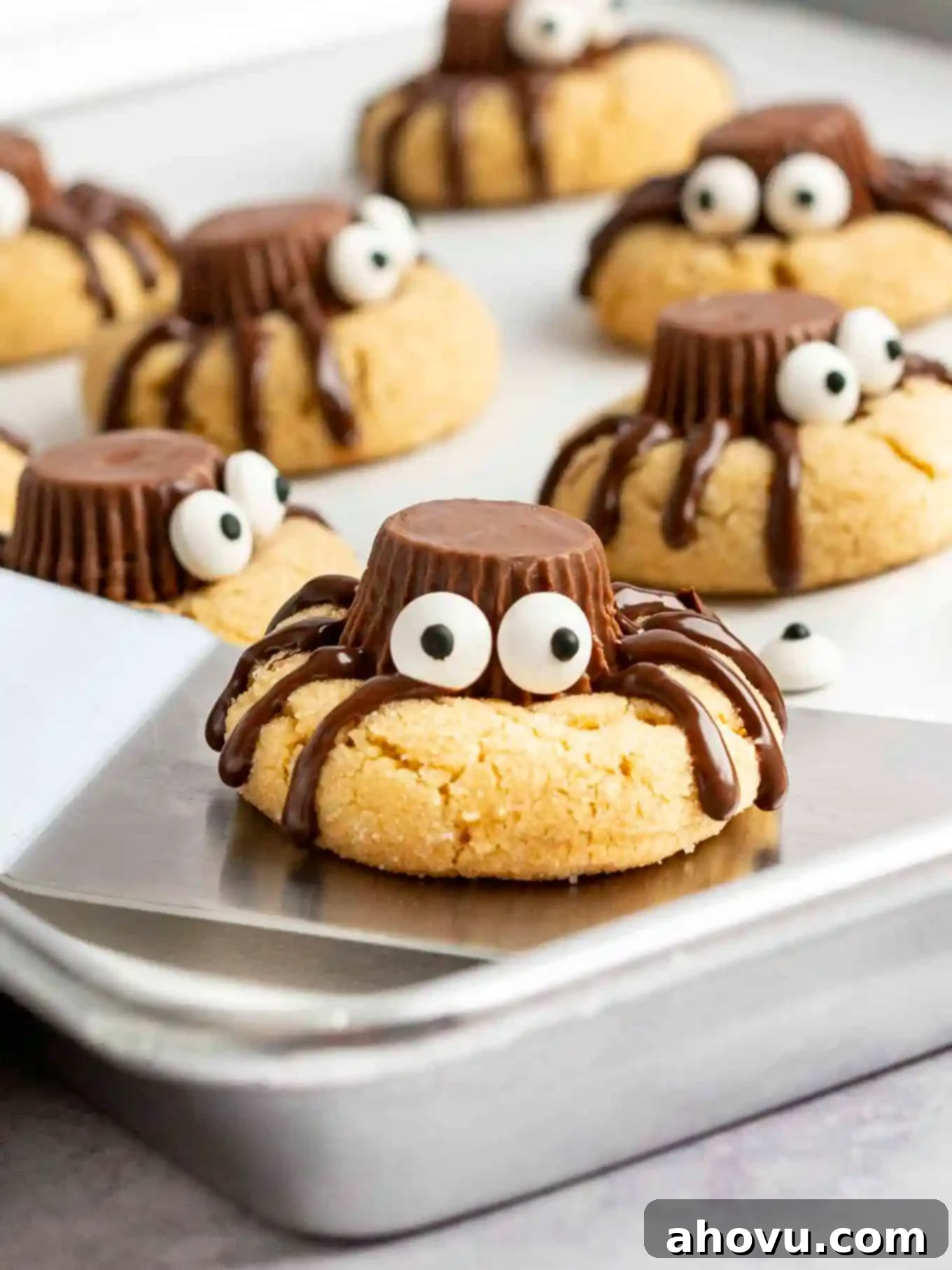 Creepy Crawly Cookie Bites 10 A spider cookie with candy eyes being lifted off a baking sheet.