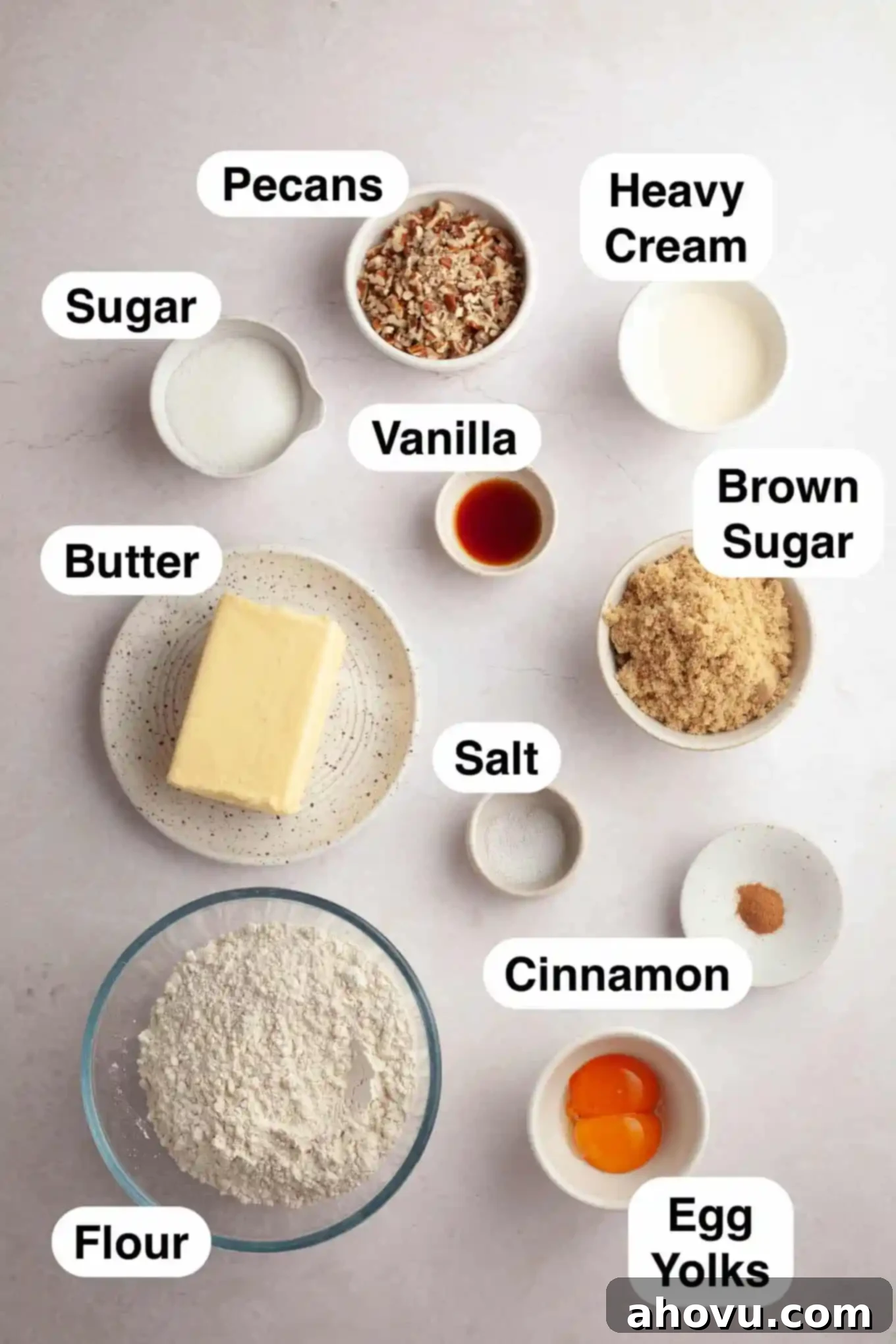 An overhead view of the ingredients laid out on a white surface, clearly showing butter, flour, brown sugar, eggs, pecans, cream, and spices, all essential for making delicious pecan pie cookies. 