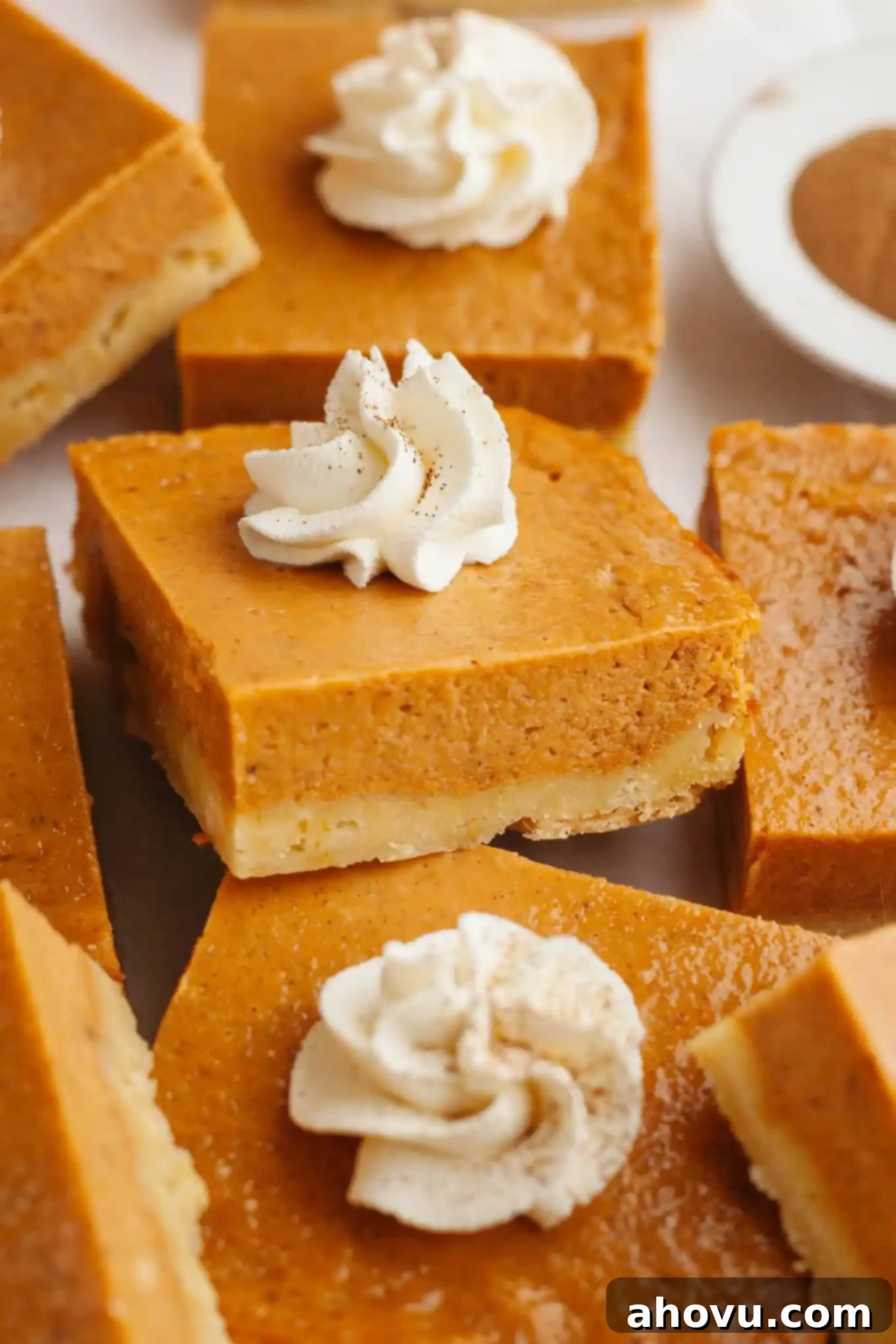 Harvest Spice Pumpkin Bars 2 Pumpkin pie bars arranged so they're partially stacked atop one another.