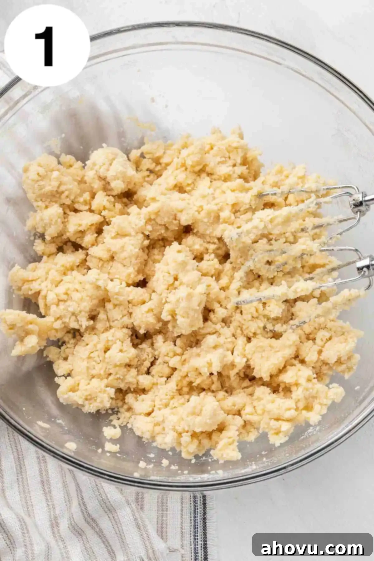 Harvest Spice Pumpkin Bars 4 An overhead view of shortbread cookie dough in a glass mixing bowl, with a rubber spatula.