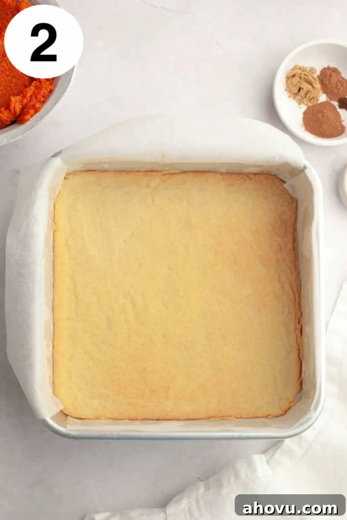 Harvest Spice Pumpkin Bars 5 An overhead view of a baked shortbread crust in a 9-inch pan.