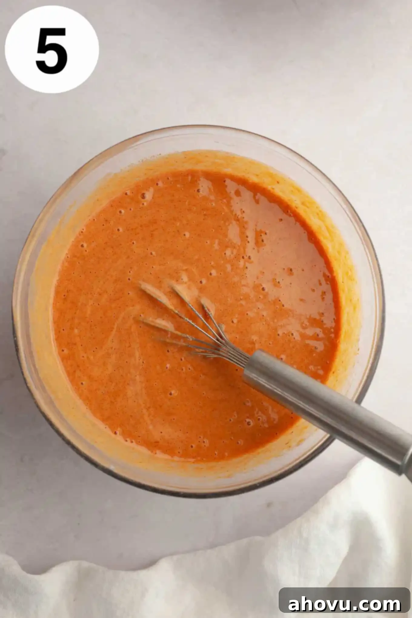 Harvest Spice Pumpkin Bars 8 An overhead view of pumpkin pie filling in a mixing bowl, with a whisk.
