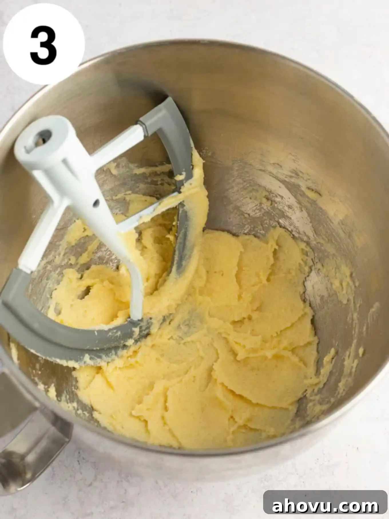 Guilt-Free Sugar Cookie Dough 6 An overhead view of the creamed butter and sugar mixture, now with vanilla and almond extracts added, being mixed in a bowl.