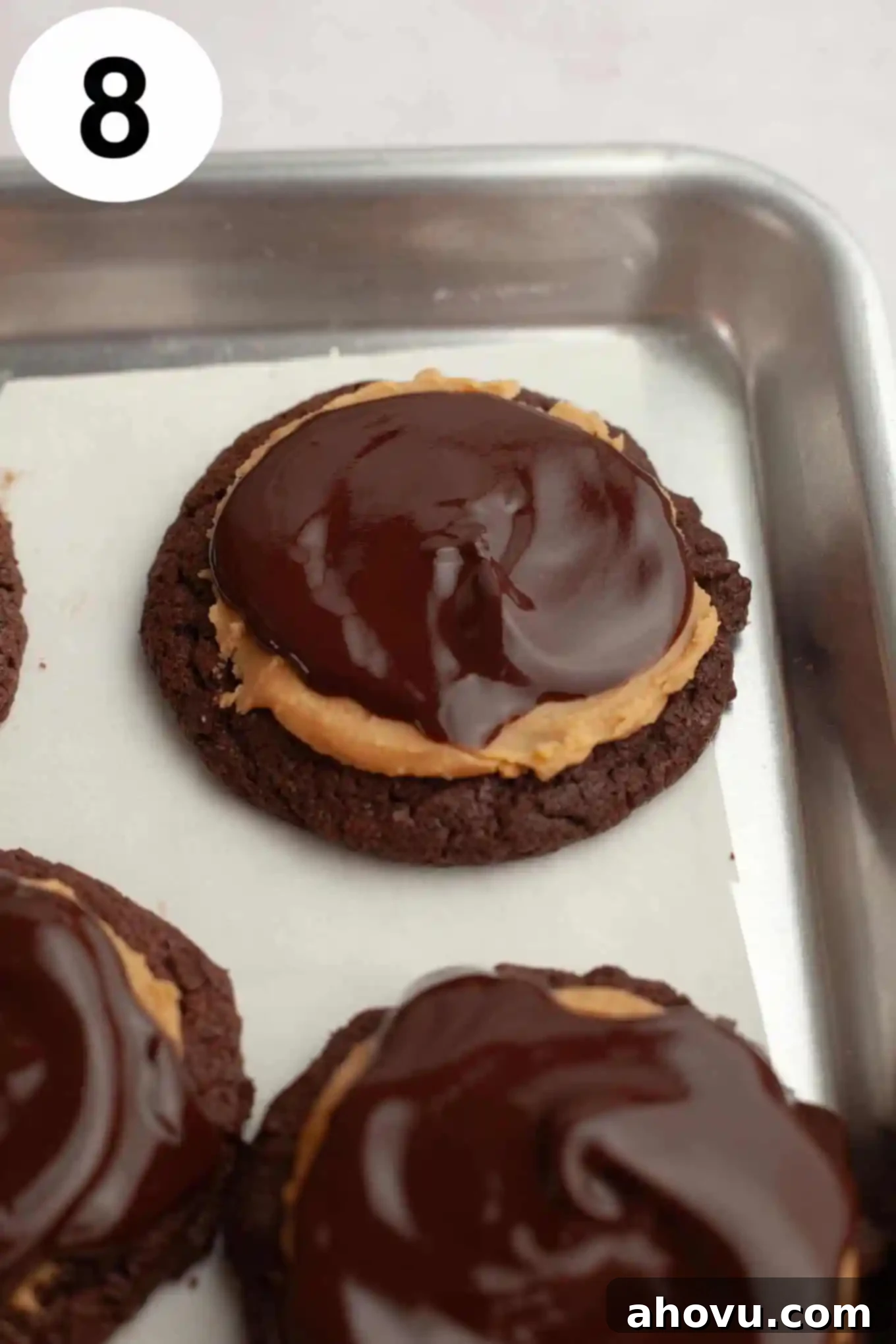 An overhead view of a tray of completed Buckeye cookies, each with a chocolate base, peanut butter center, and a beautiful chocolate topping, ready to be chilled and enjoyed.