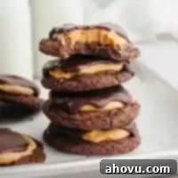 A stack of buckeye cookies, perfectly displaying the layers of chocolate, peanut butter, and a chocolate topping, ready to be enjoyed.