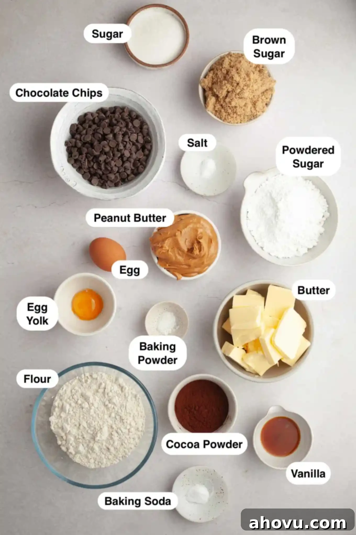 An overhead view of the essential ingredients laid out for making chocolate peanut butter Buckeye cookies, including various sugars, eggs, flour, cocoa powder, peanut butter, and chocolate chips.