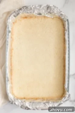 The baked shortbread crust in a pan lined with aluminum foil.