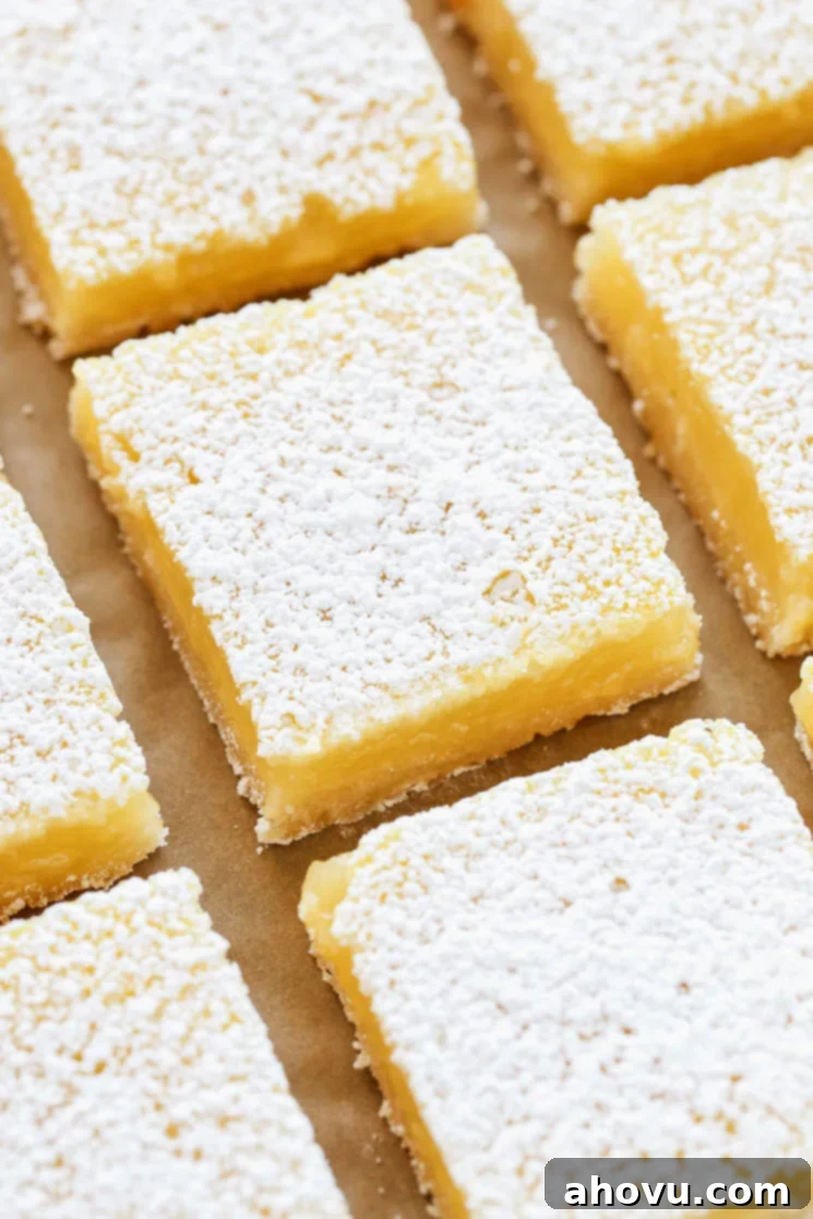 Sliced lemon bars on a piece of brown parchment paper.