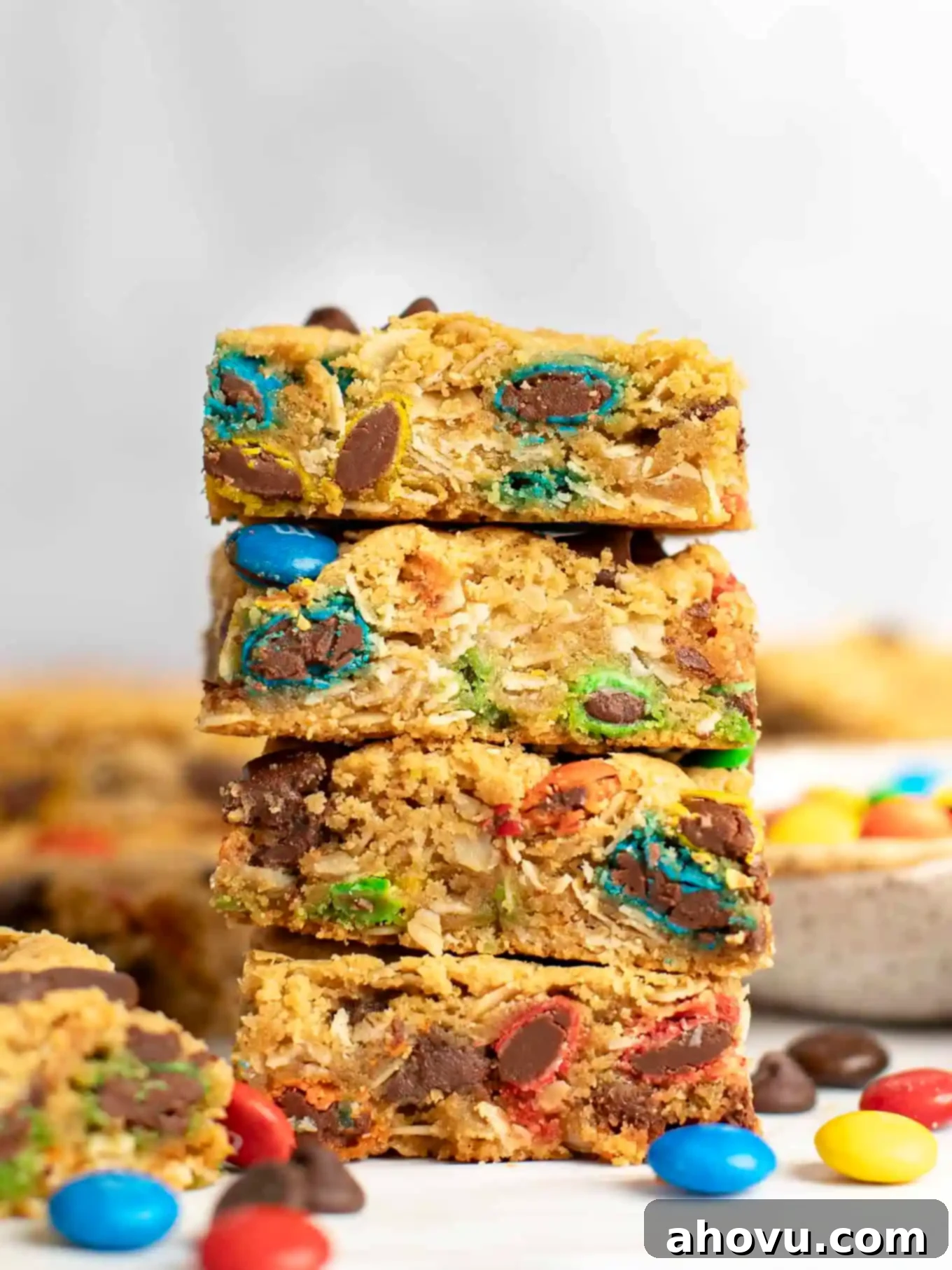 A stack of four monster cookie bars, surrounded by M&M's. 