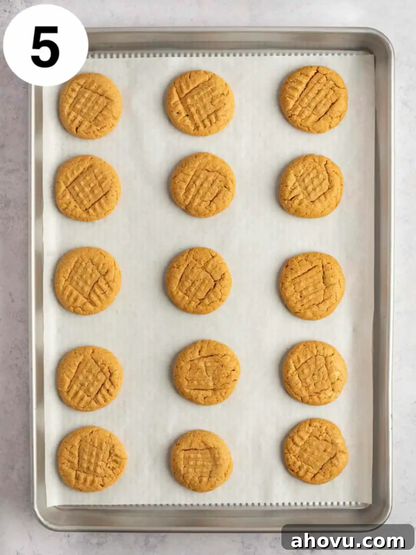 An overhead view of 3 ingredient peanut butter cookies on a parchment lined baking sheet. 