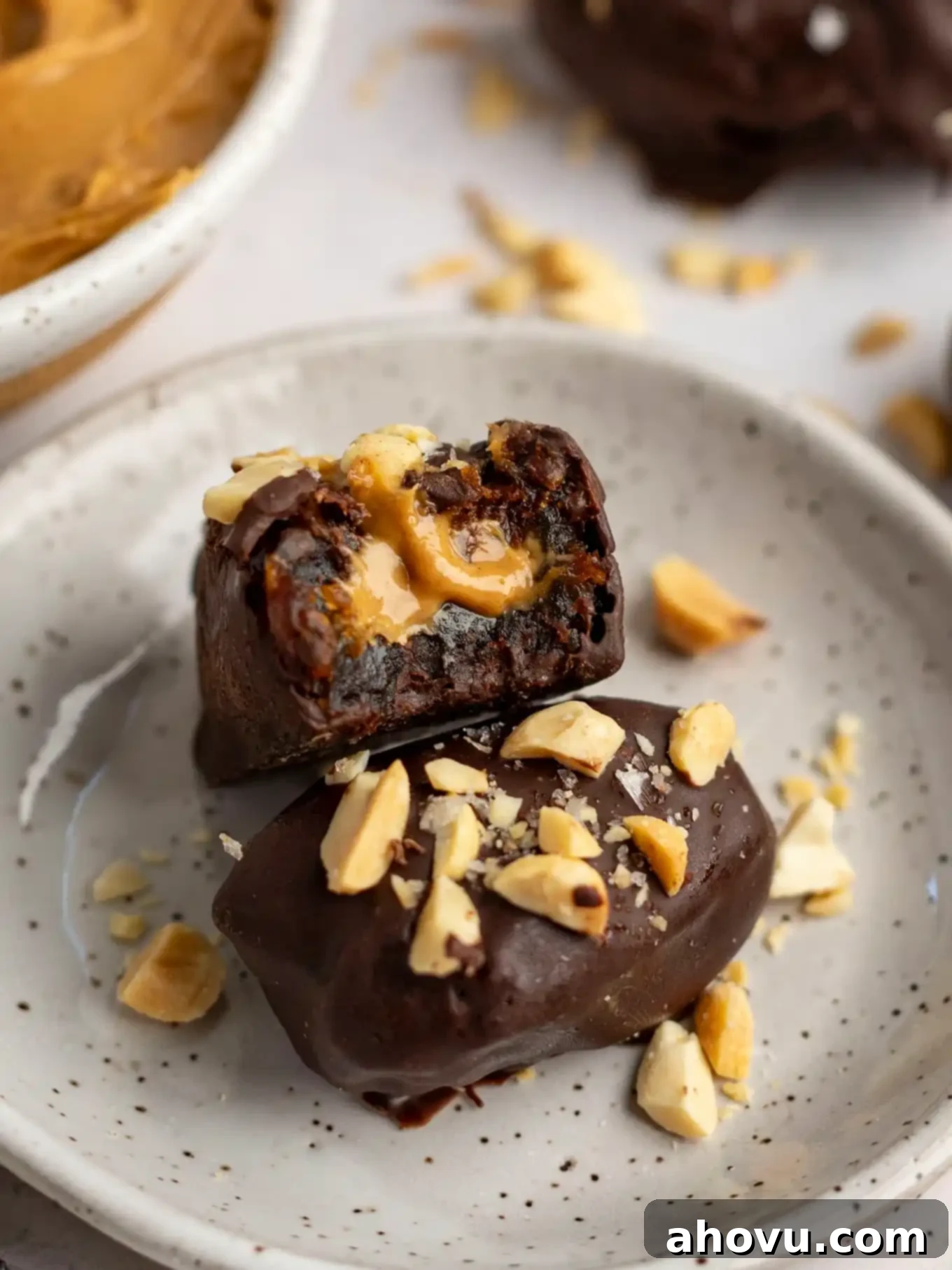 A peanut butter stuffed date with a bite missing, resting on another date. 