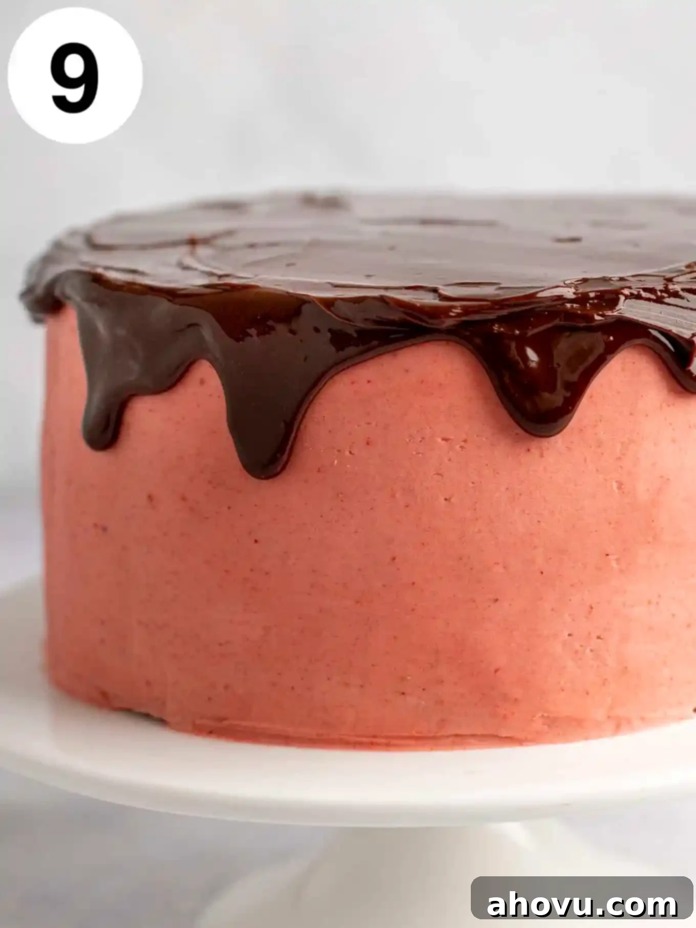 A strawberry frosted layer cake topped with chocolate ganache. 