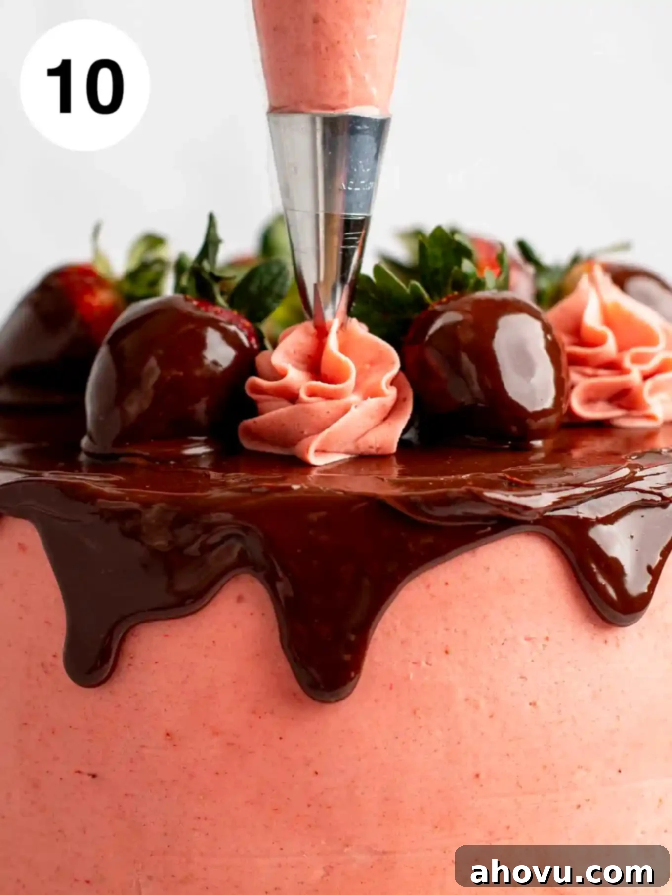 A process shot showing strawberry frosting being piped on top.