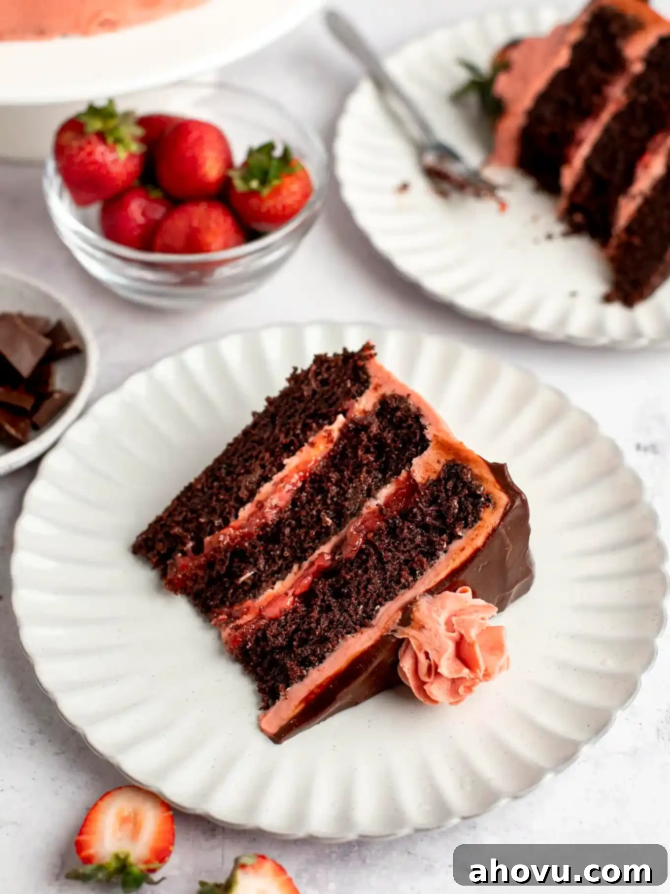 A slice of chocolate cake layered with strawberry filling and frosting. 
