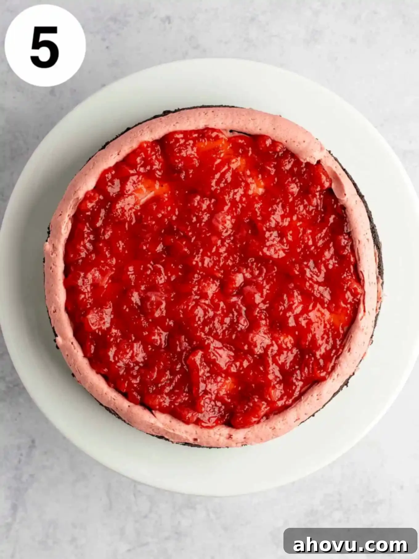 An overhead view of strawberry filling on a chocolate cake layer. 
