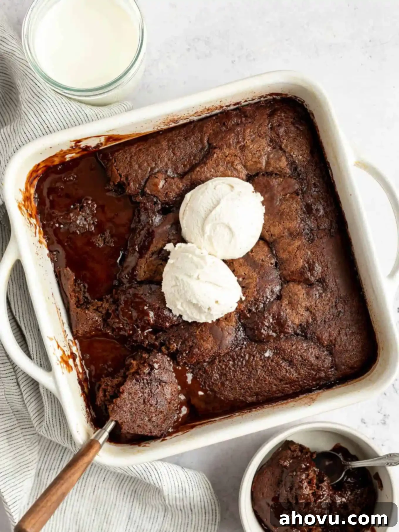 Decadent Chocolate Pudding Cake 2 An overhead view of fudgy chocolate pudding cake in a baking dish, topped with vanilla ice cream.