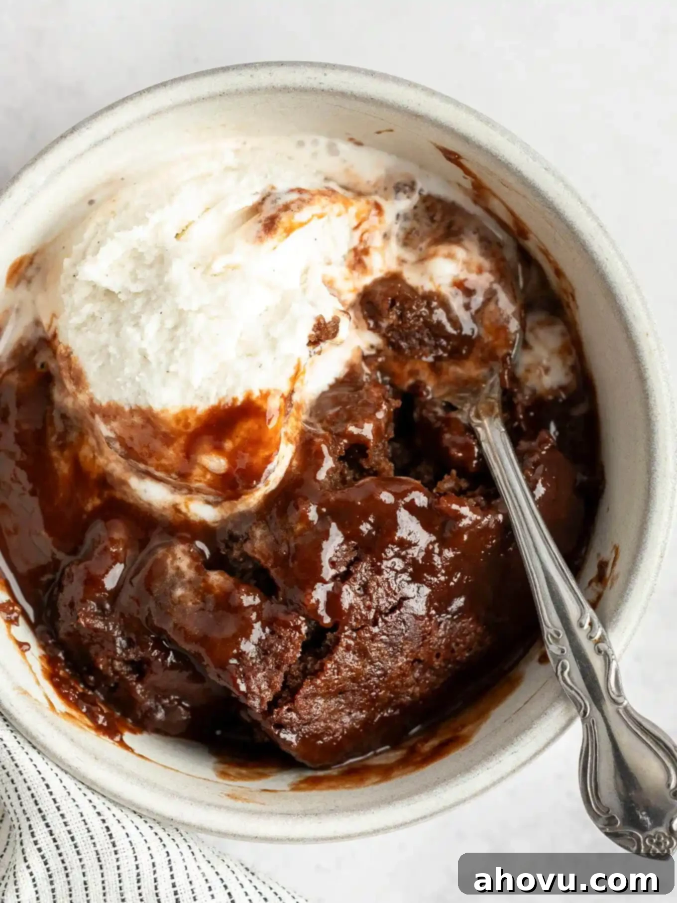 Decadent Chocolate Pudding Cake 11 An overhead view of chocolate pudding cake in a bowl, topped with vanilla ice cream.