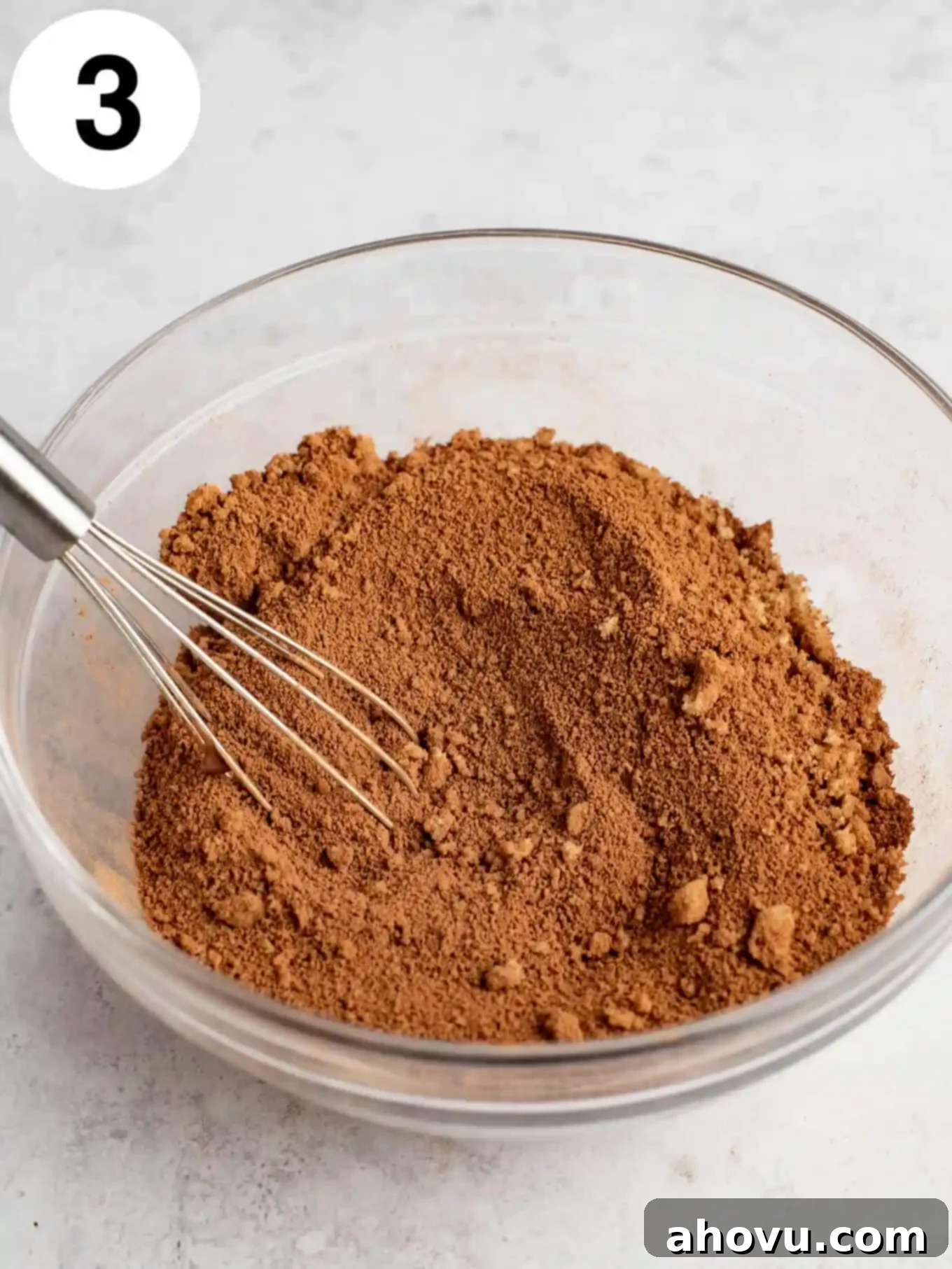 Decadent Chocolate Pudding Cake 6 A mixture of cocoa powder and brown sugar in a mixing bowl, with a whisk.