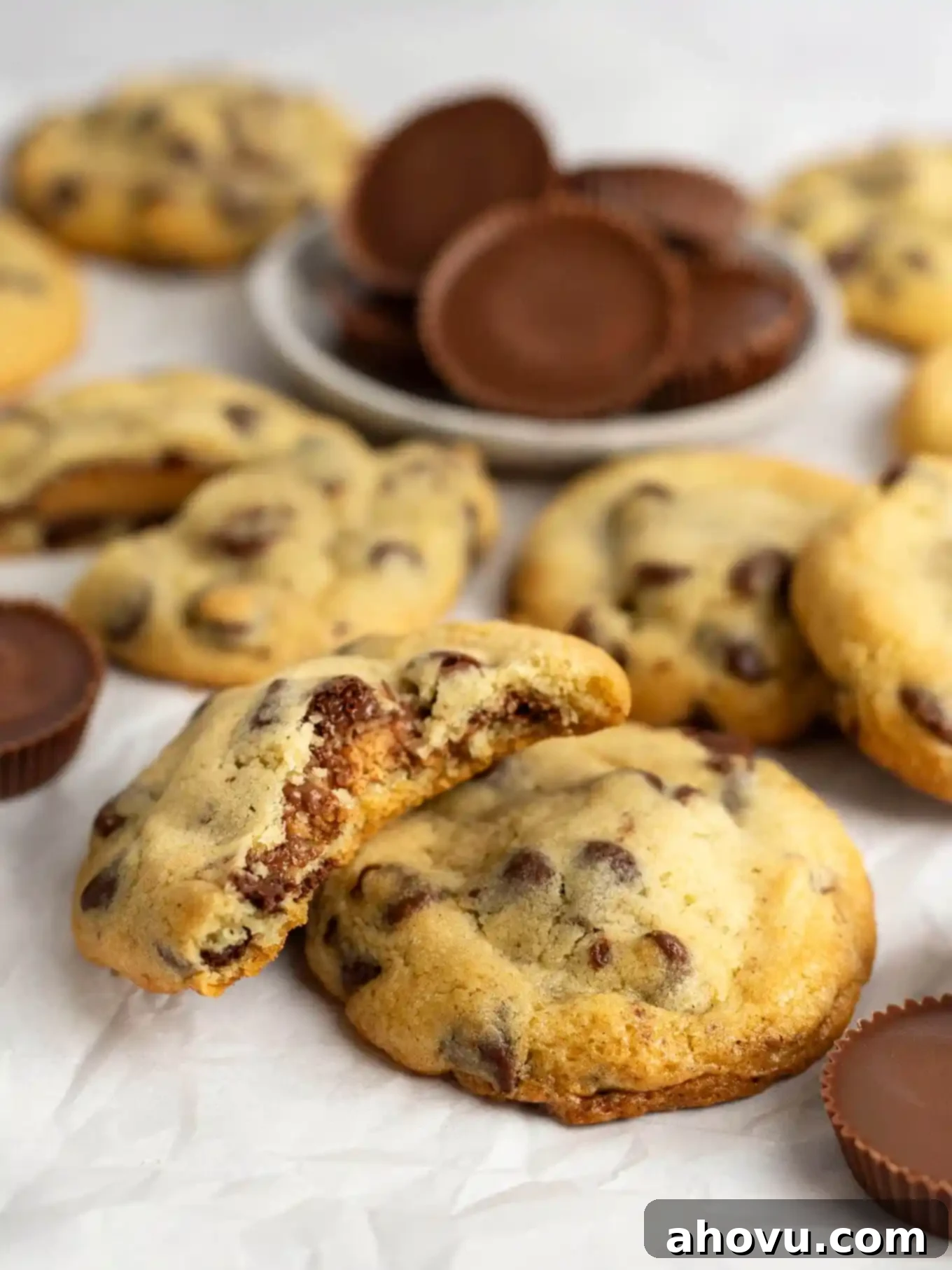 Reese's Peanut Butter Explosion Cookies 11 A Reese's stuffed chocolate chip cookie with a bite missing resting on another cookie.