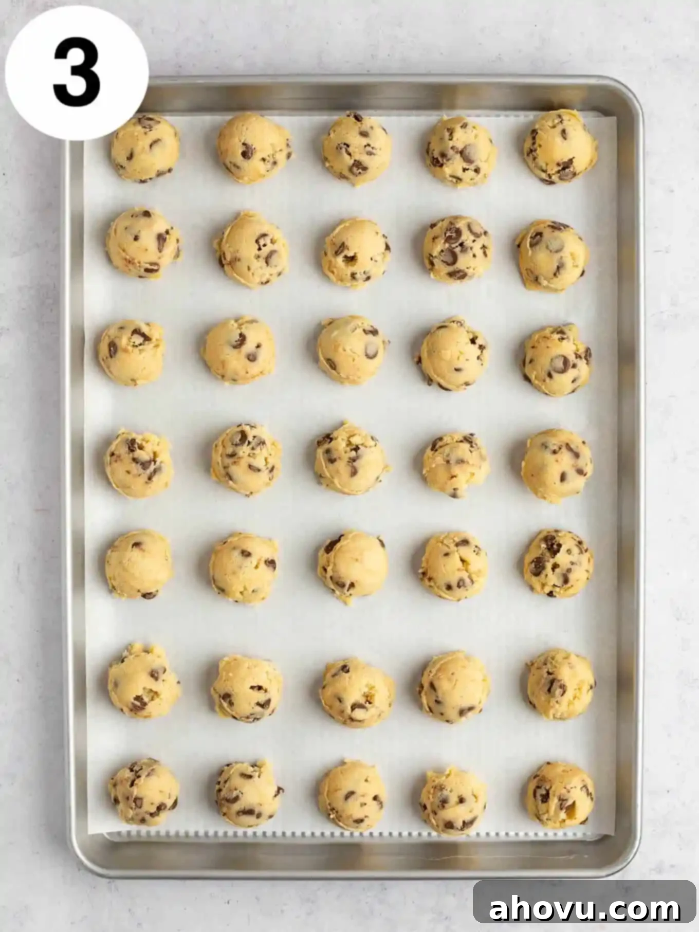 Reese's Peanut Butter Explosion Cookies 6 An overhead view of balls of chocolate chip cookie dough on a baking sheet.