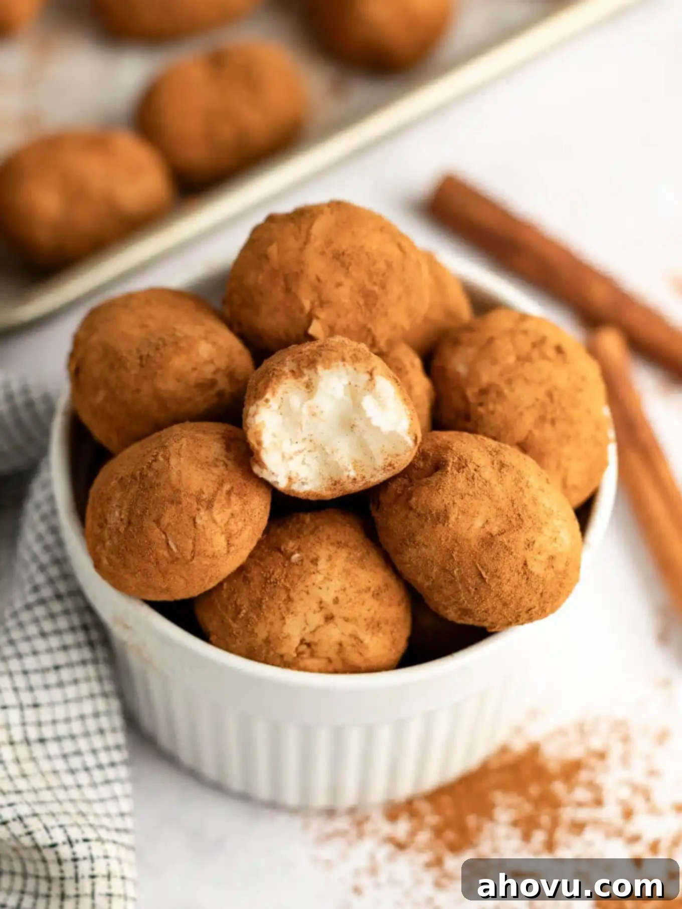 A ramekin full of delightful Irish potato candy. One candy has a bite missing, revealing its creamy coconut interior.