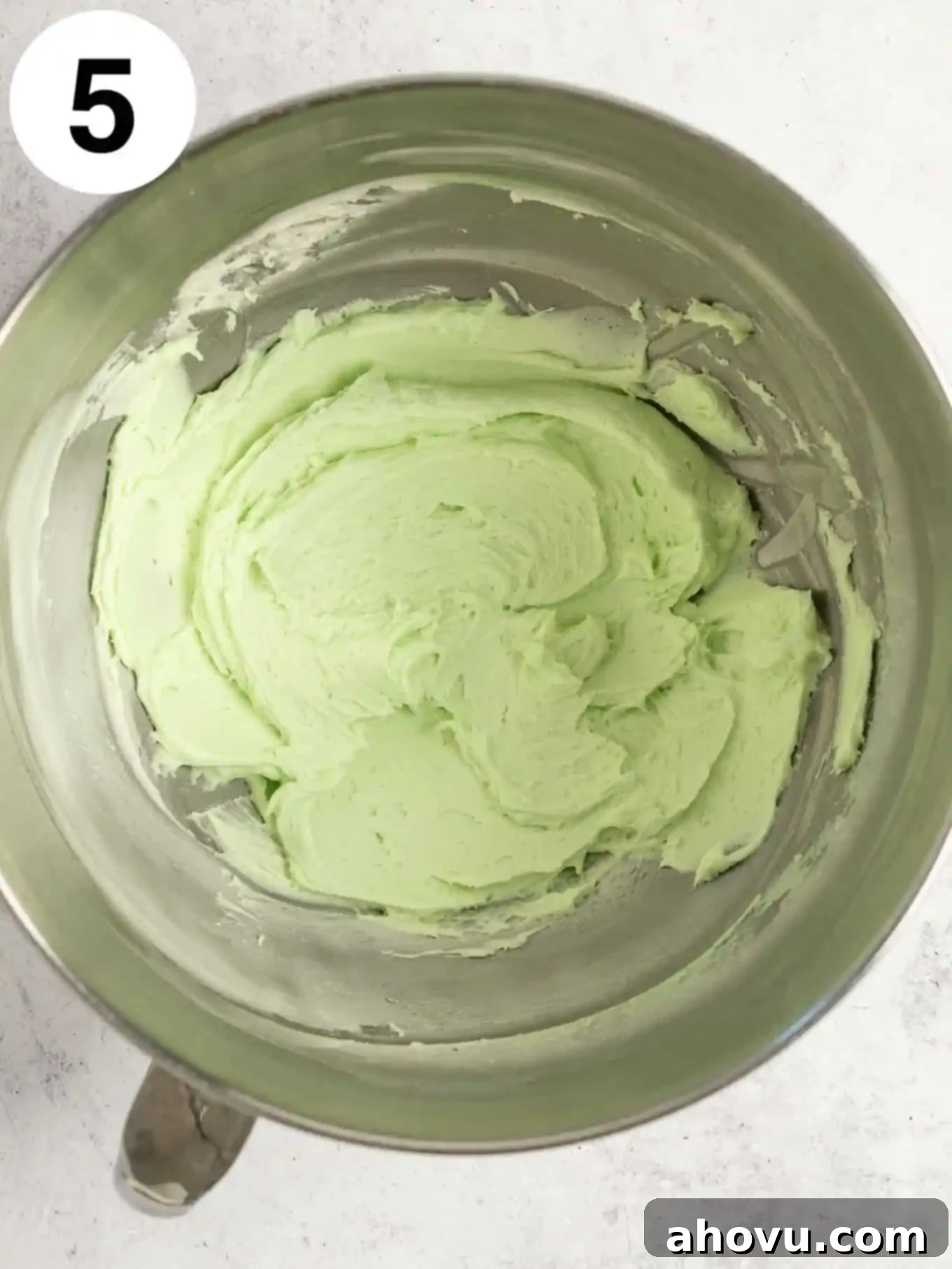 Decadent Mint Chocolate Brownies 8 A vibrant, smooth green mint frosting gracefully mixed in the bowl of a stand mixer, showcasing its creamy texture.
