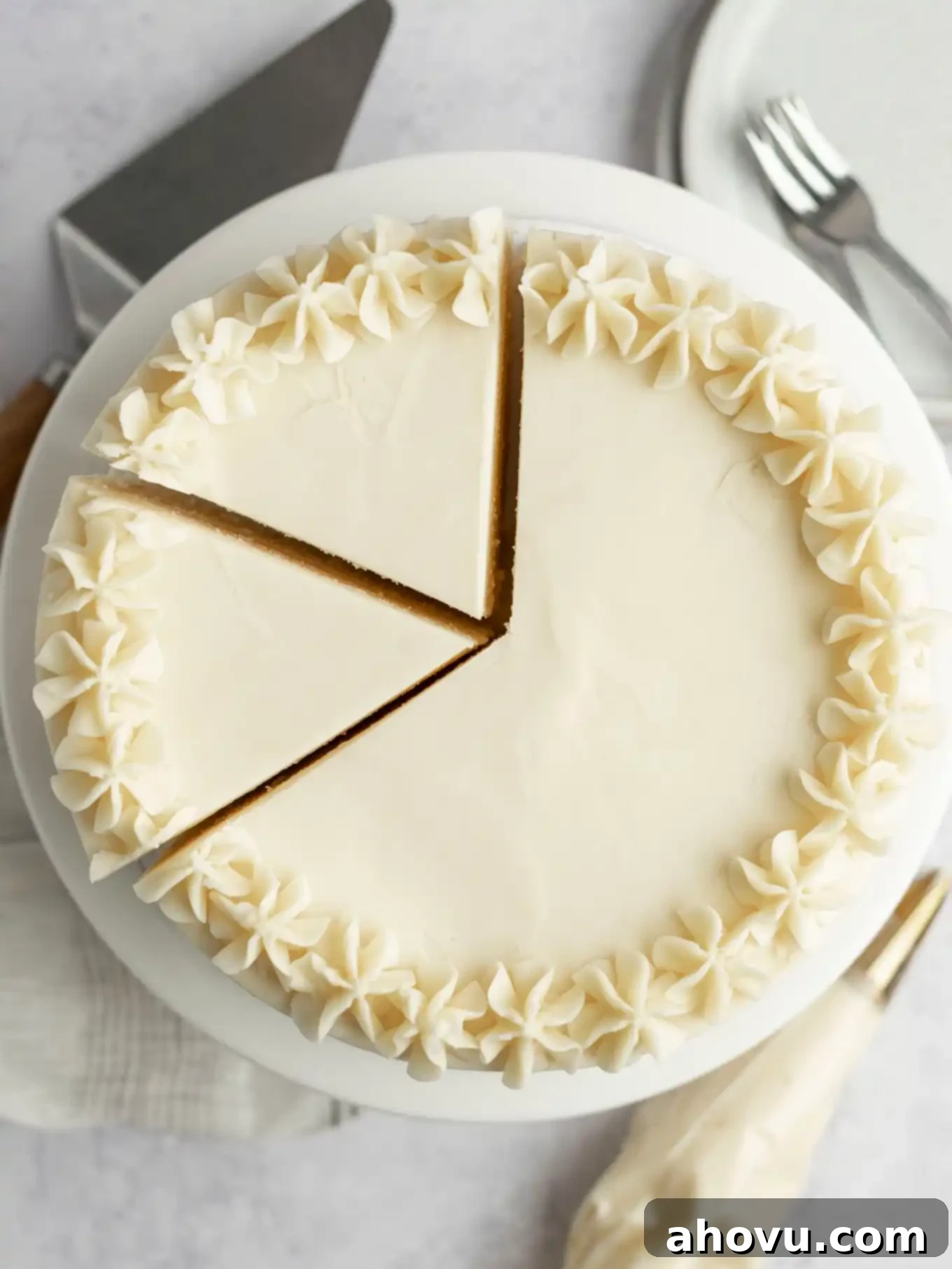 An overhead view of a frosted white cake with two large slices cut. 