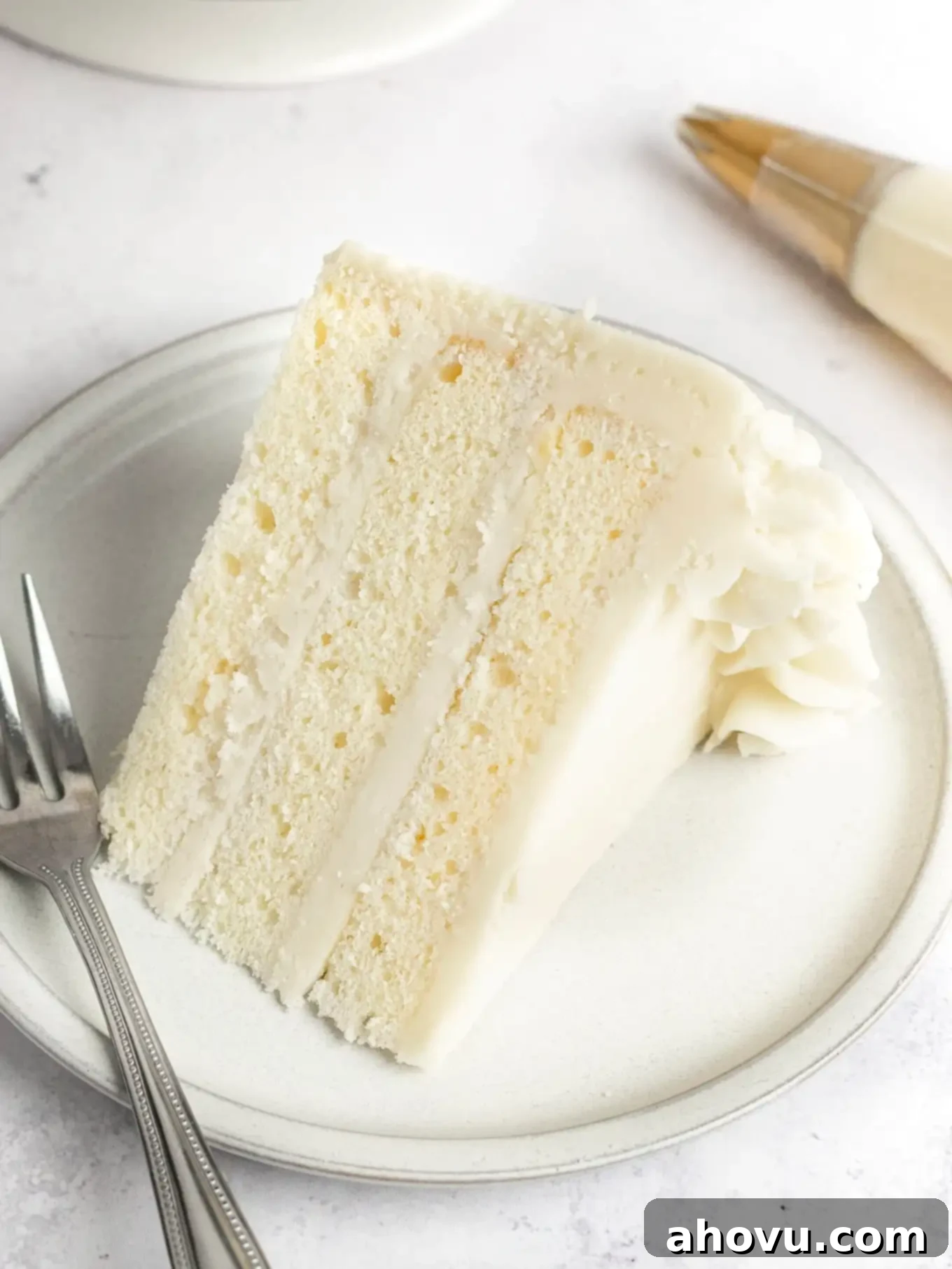 A slice of cake topped with buttercream frosting. 