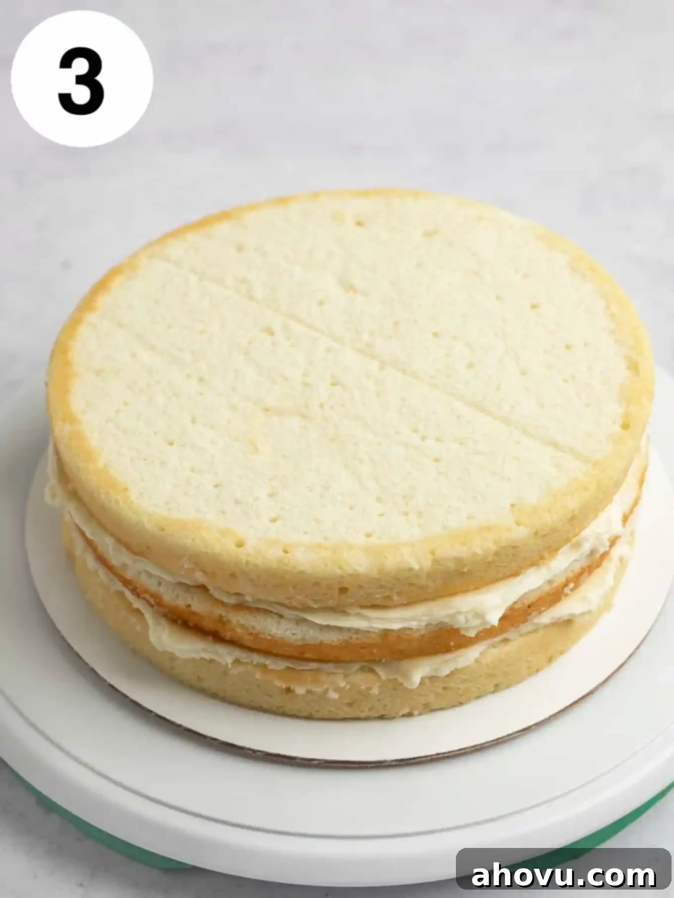 A process shot showing a stacked layer cake ready for frosting. 