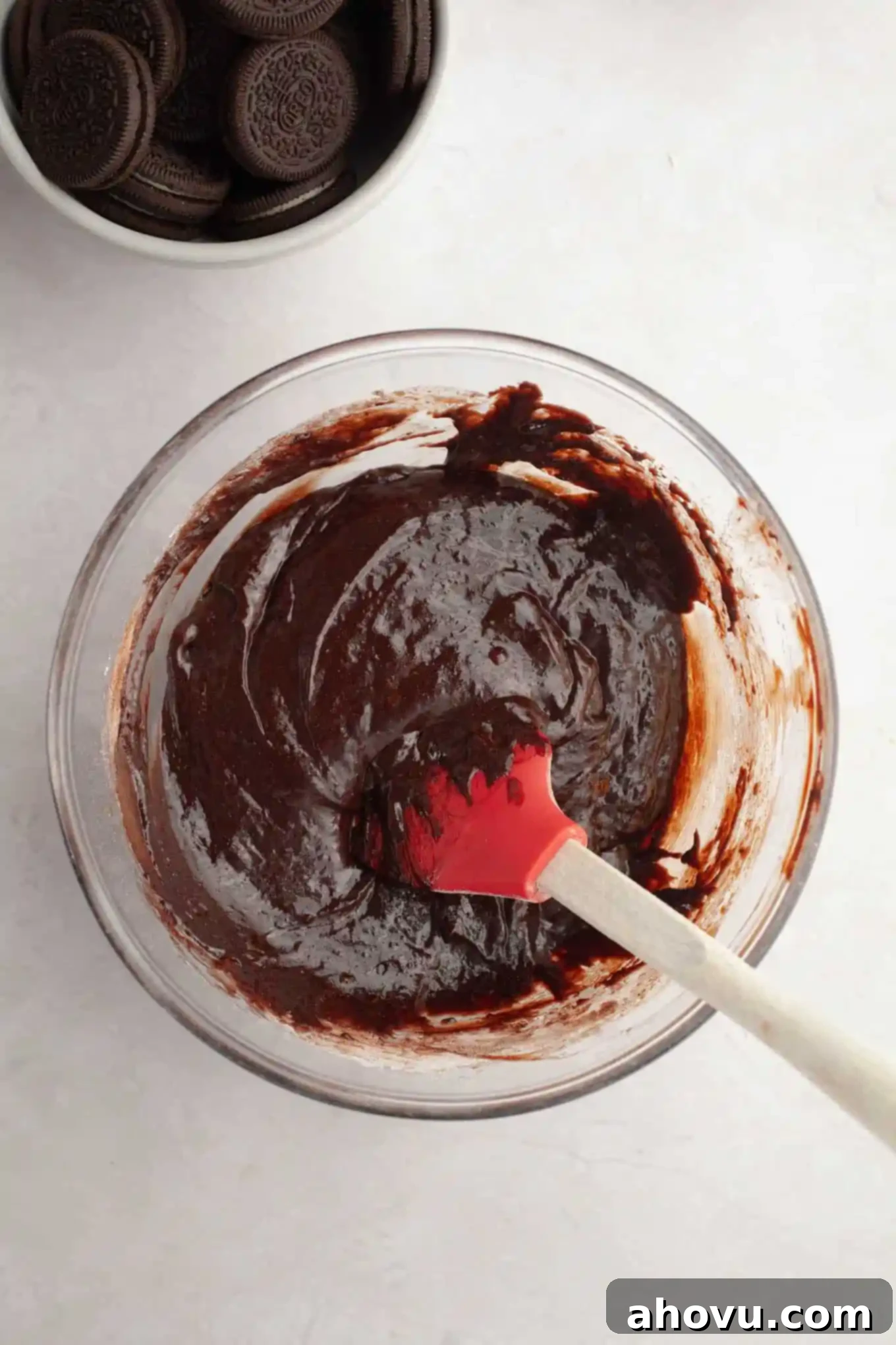 Ultimate Oreo Brownies 5 An overhead view of brownie batter in a mixing bowl with a spatula.