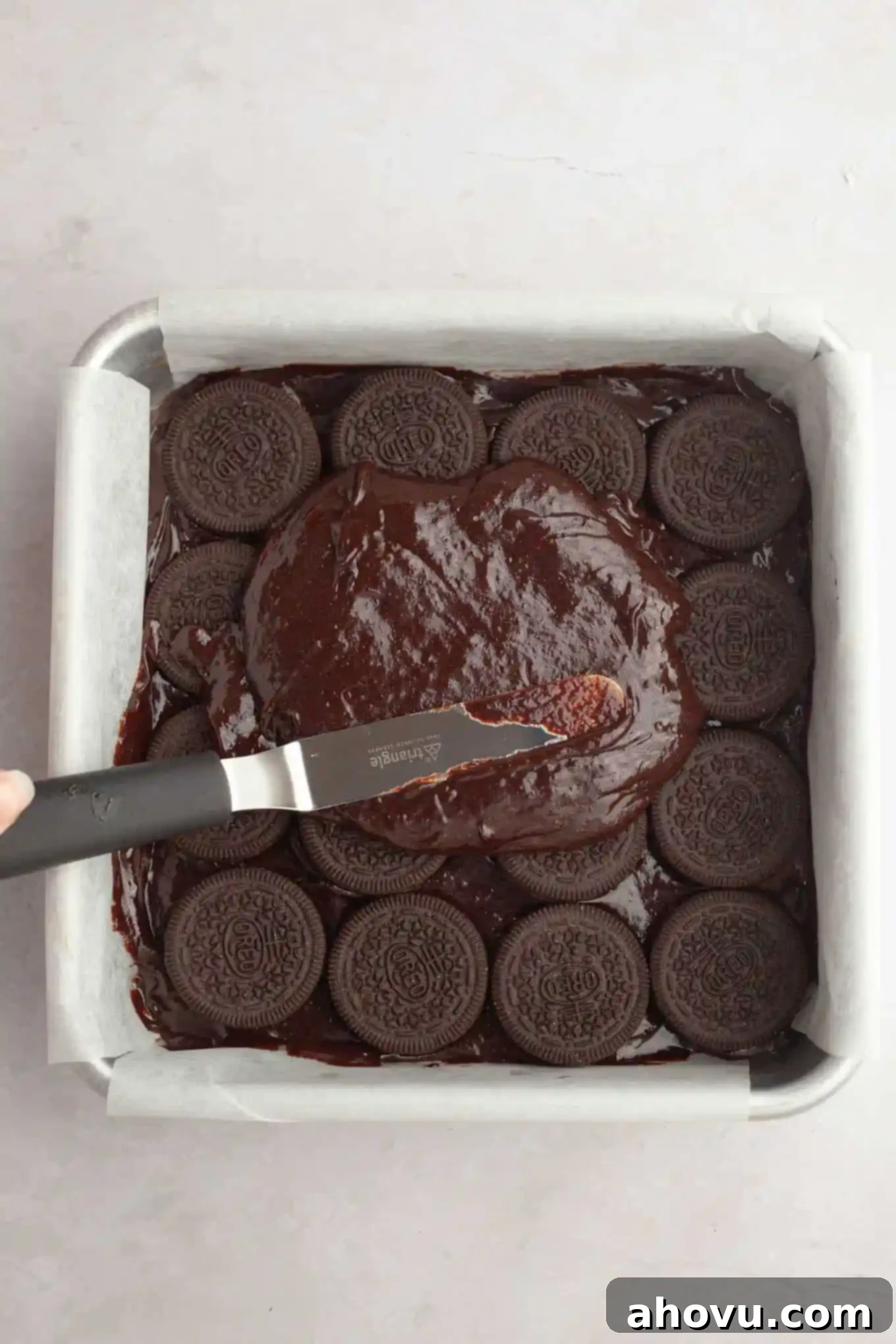 Ultimate Oreo Brownies 6 An overhead view of brownie batter being smoothed over a layer of Oreos.