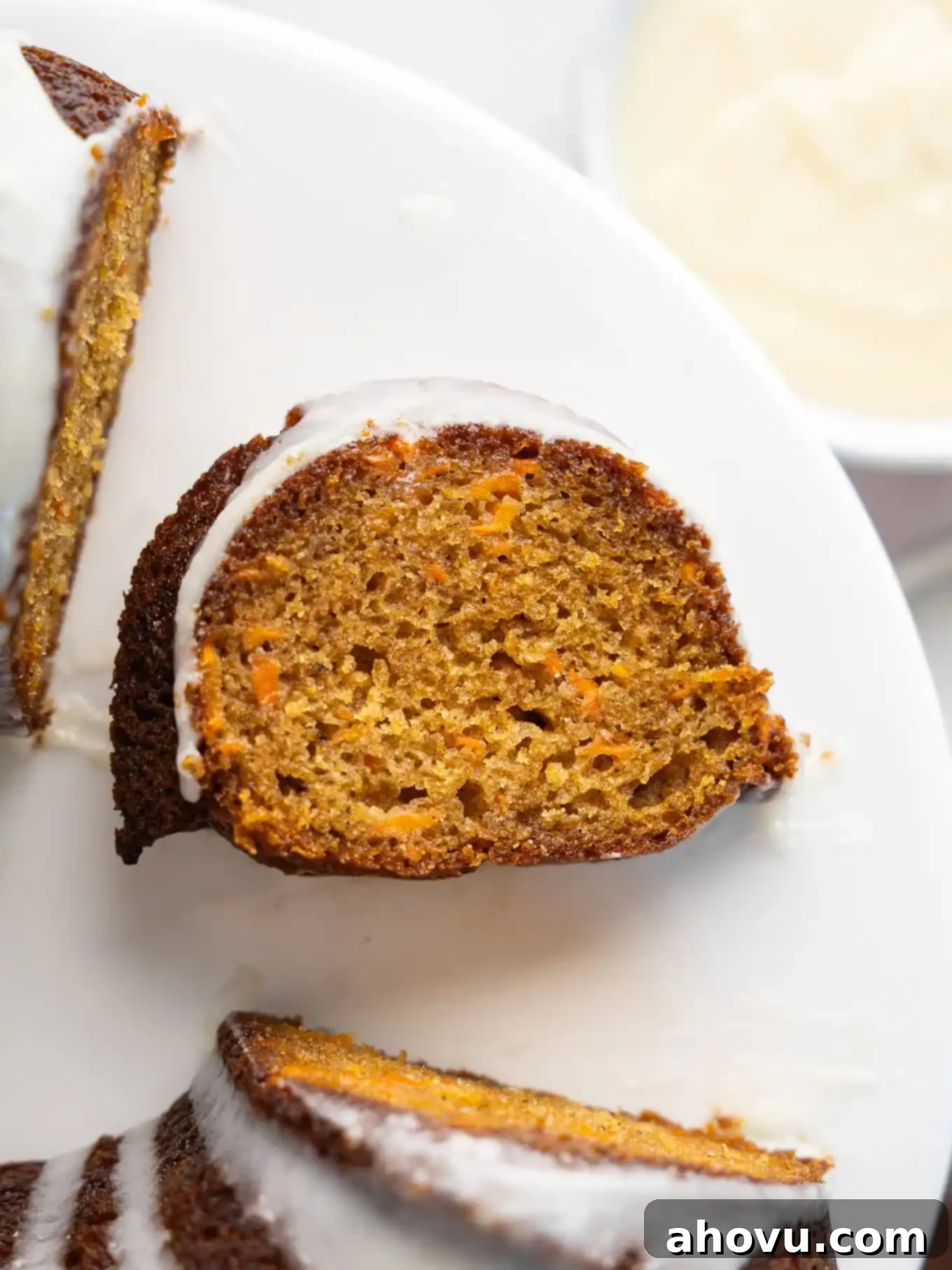An overhead view of a slice of carrot cake on its side, in the middle of a bundt ring. 