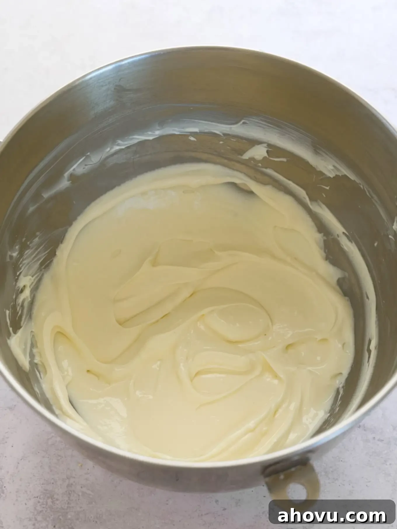 An overhead view of cheesecake filling in a mixing bowl. 